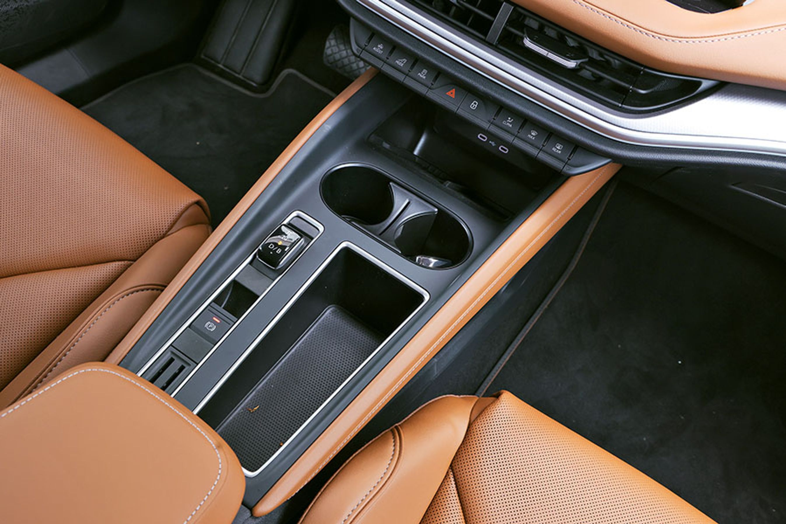 En lille gearvælger er placeret mellem forsæderne. Den er for så vidt let at betjene, men den optager lidt plads, så kopholderne ikke er store nok til f.eks. en drikkedunk. Her have en løsning med gearvælgeren ved rattet været at foretrække.