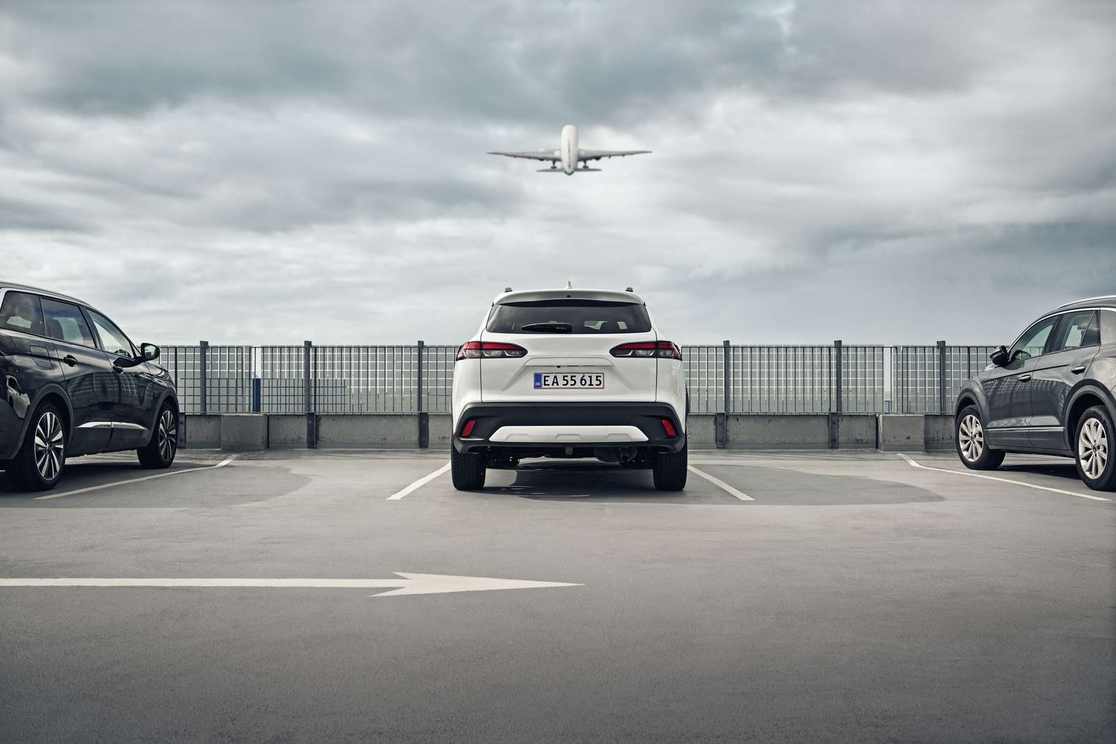 Parkeret bil med fly over sig