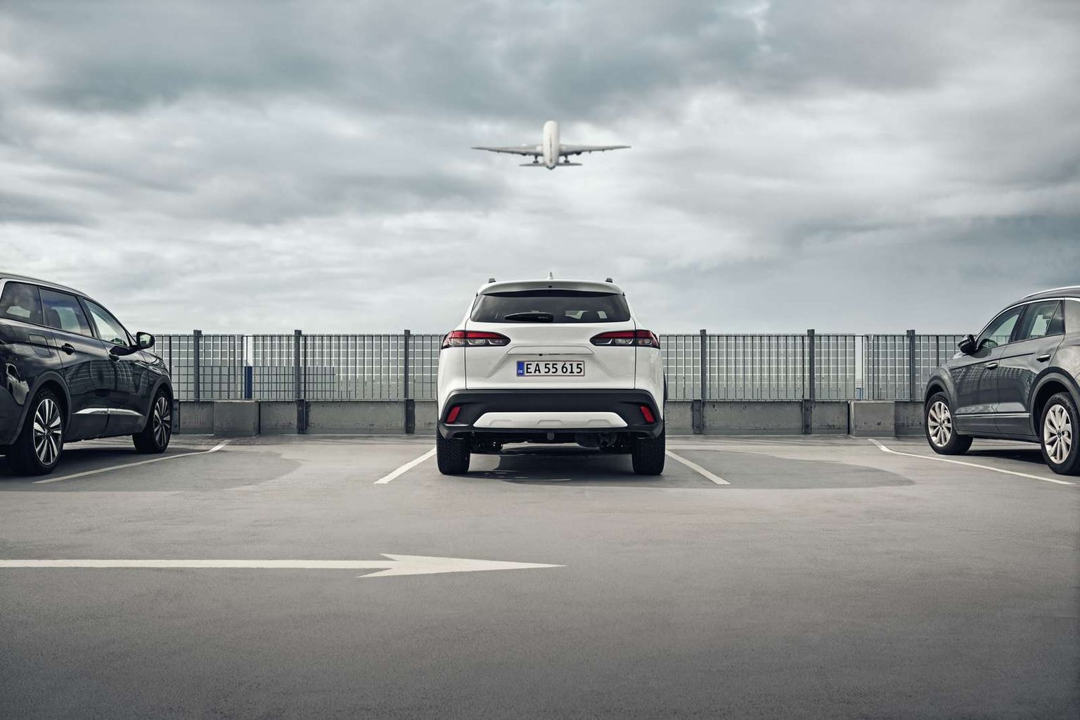 Parkeret bil med fly over sig