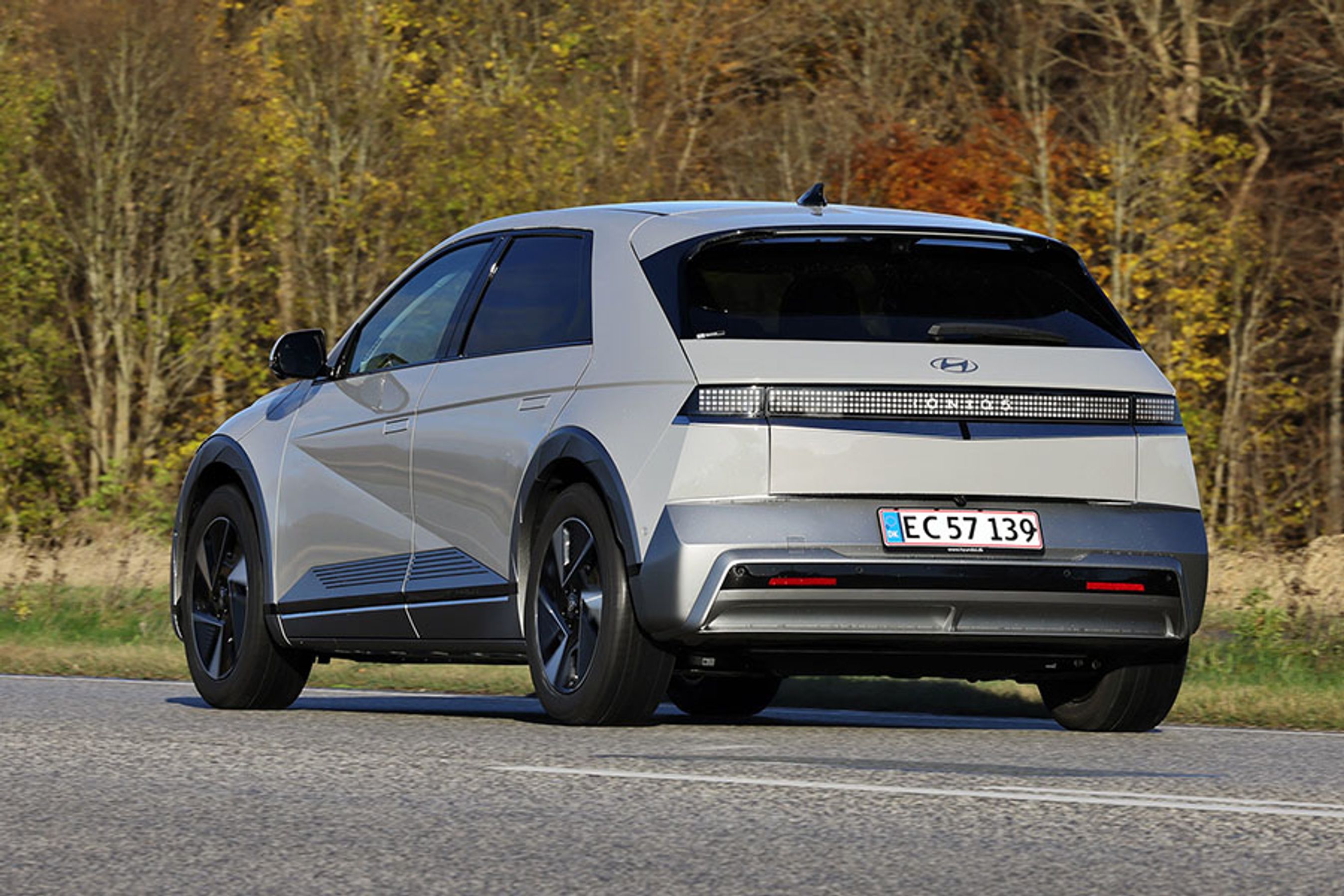 Hyundai Ioniq 5 set bagfra kører på landevej med træer i baggrunden