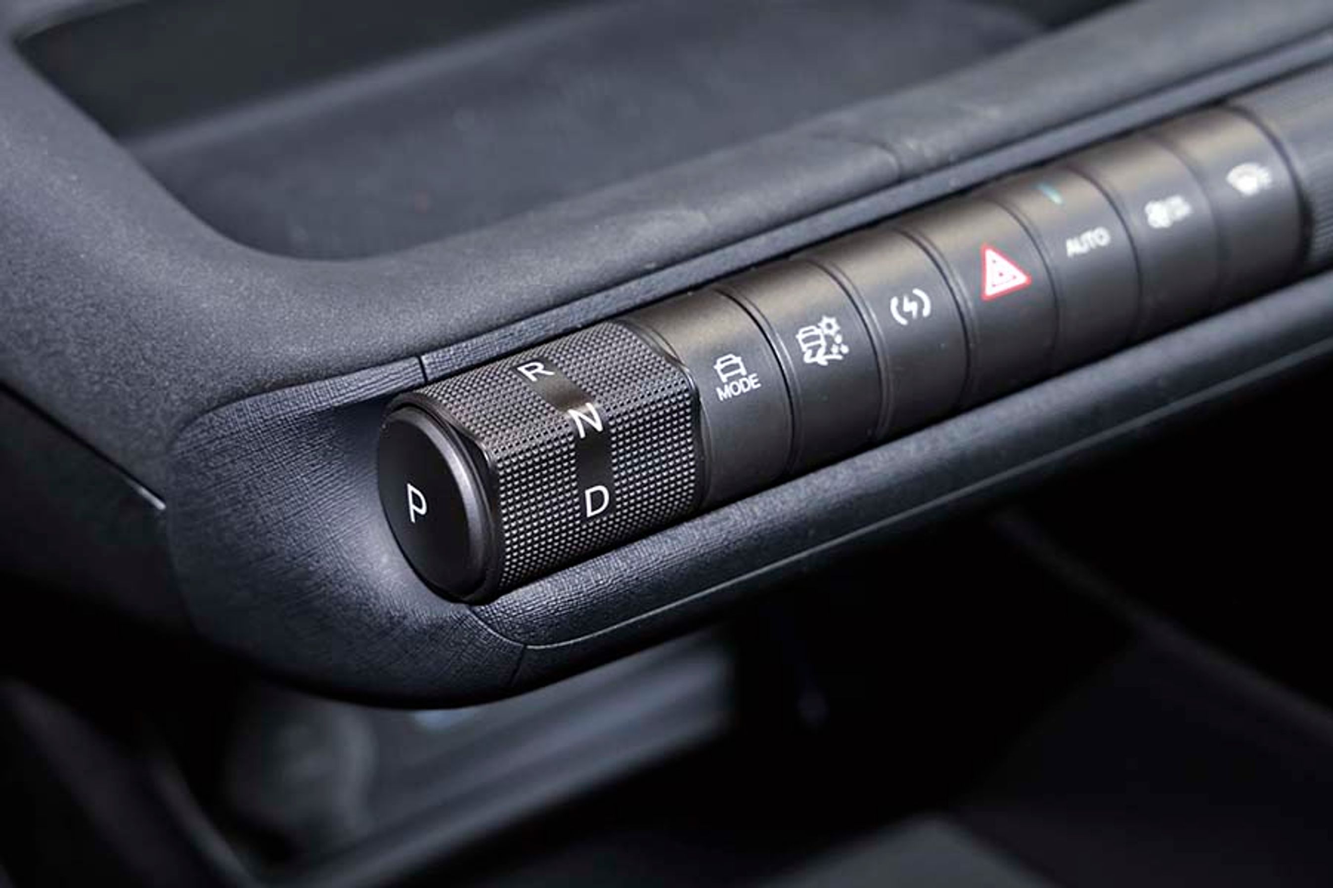 Under skærmen sidder en række knapper, hvor den længst til venstre er selve gearvælgeren. 