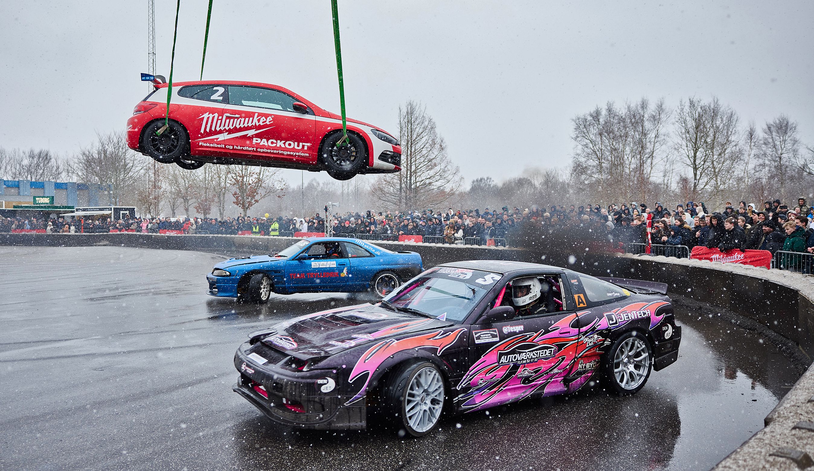 Biler racer på lukket område med en bil hængende i luften.