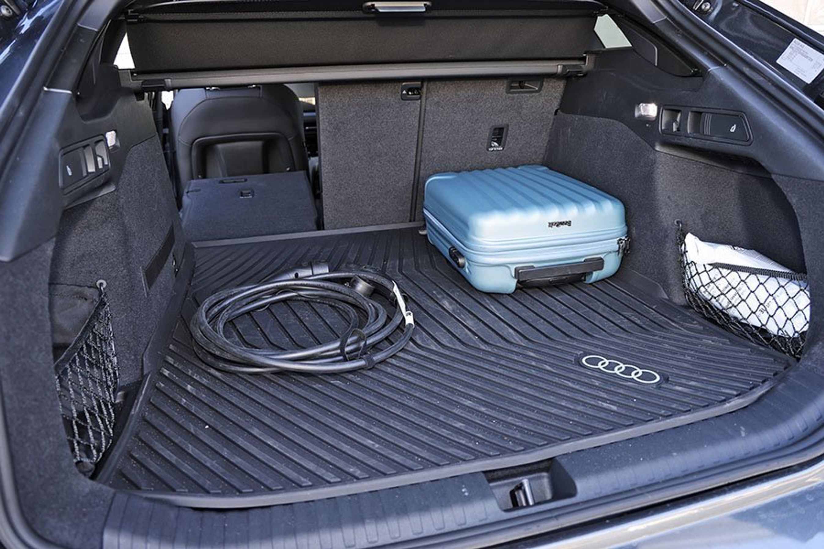Bagagerum med blå kuffert og ladekabel i en Audi A6 Avant e-tron