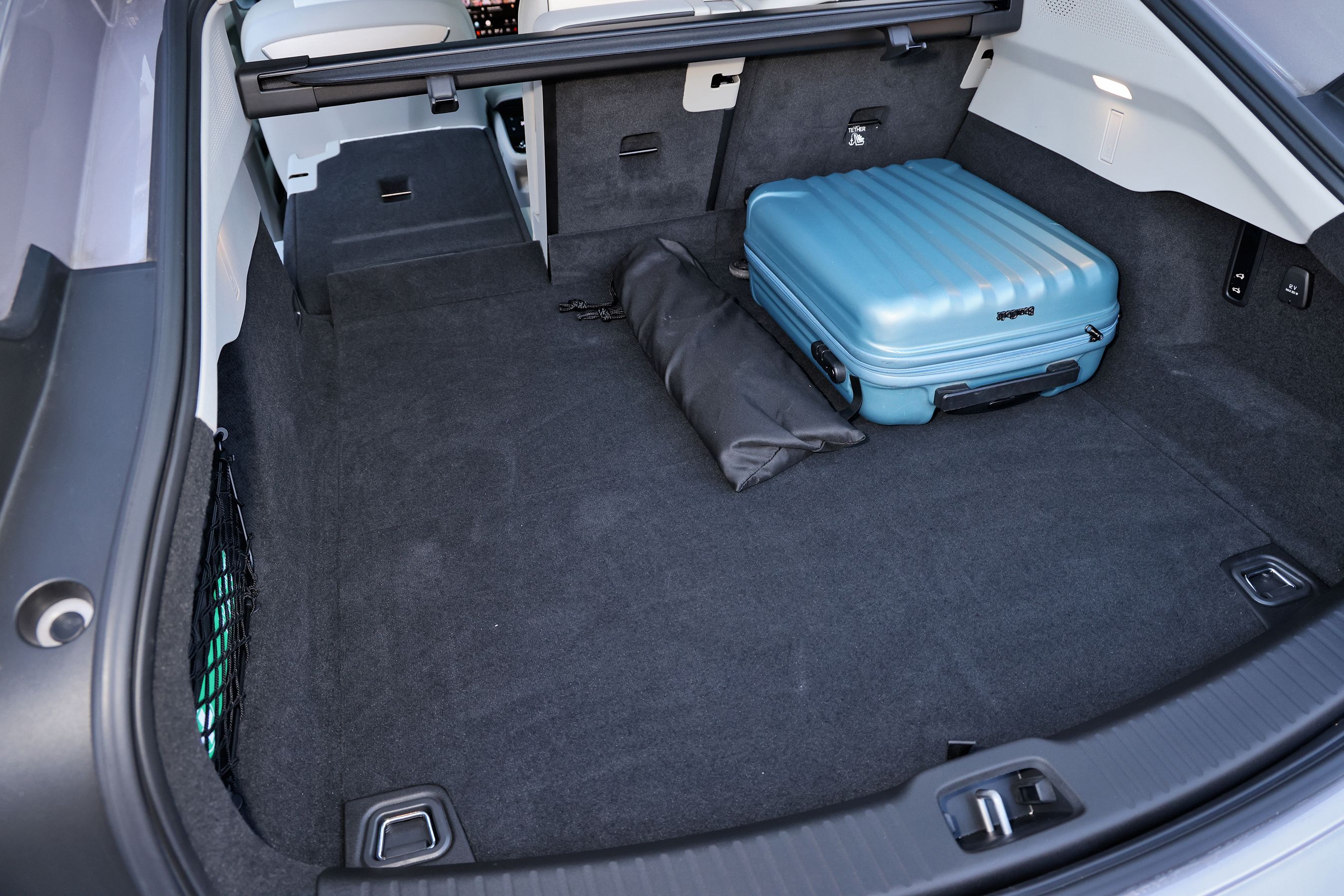 Bagagerum med blå kuffert i en Volvo ES90