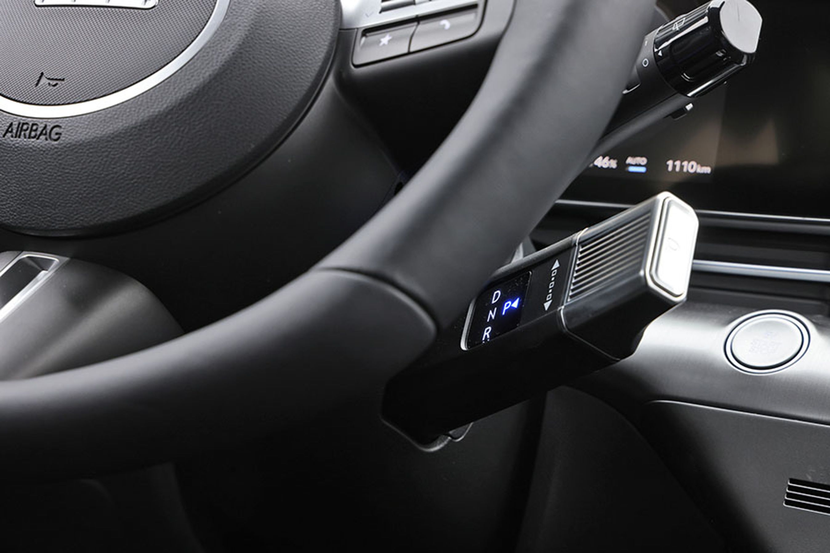 Gearvælgeren er placeret bag rattet i højre side og sidder ret tæt på knæet. Den runde startknap kan være svær at se for rattet.