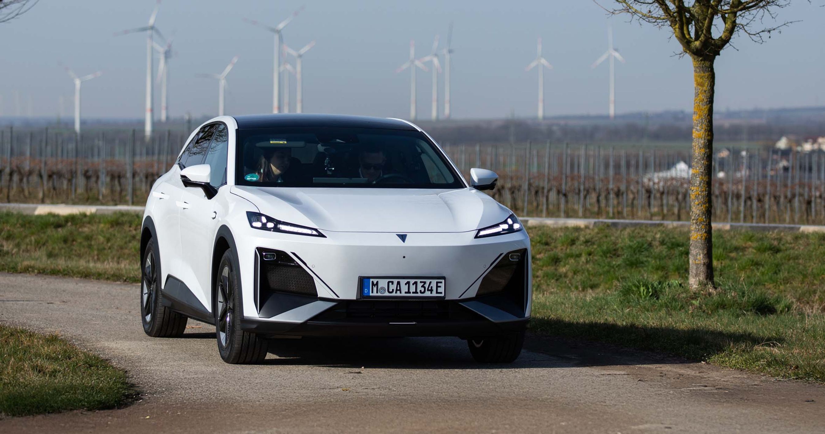 Deepal S07 kører i sving med vindmøller i baggrunden