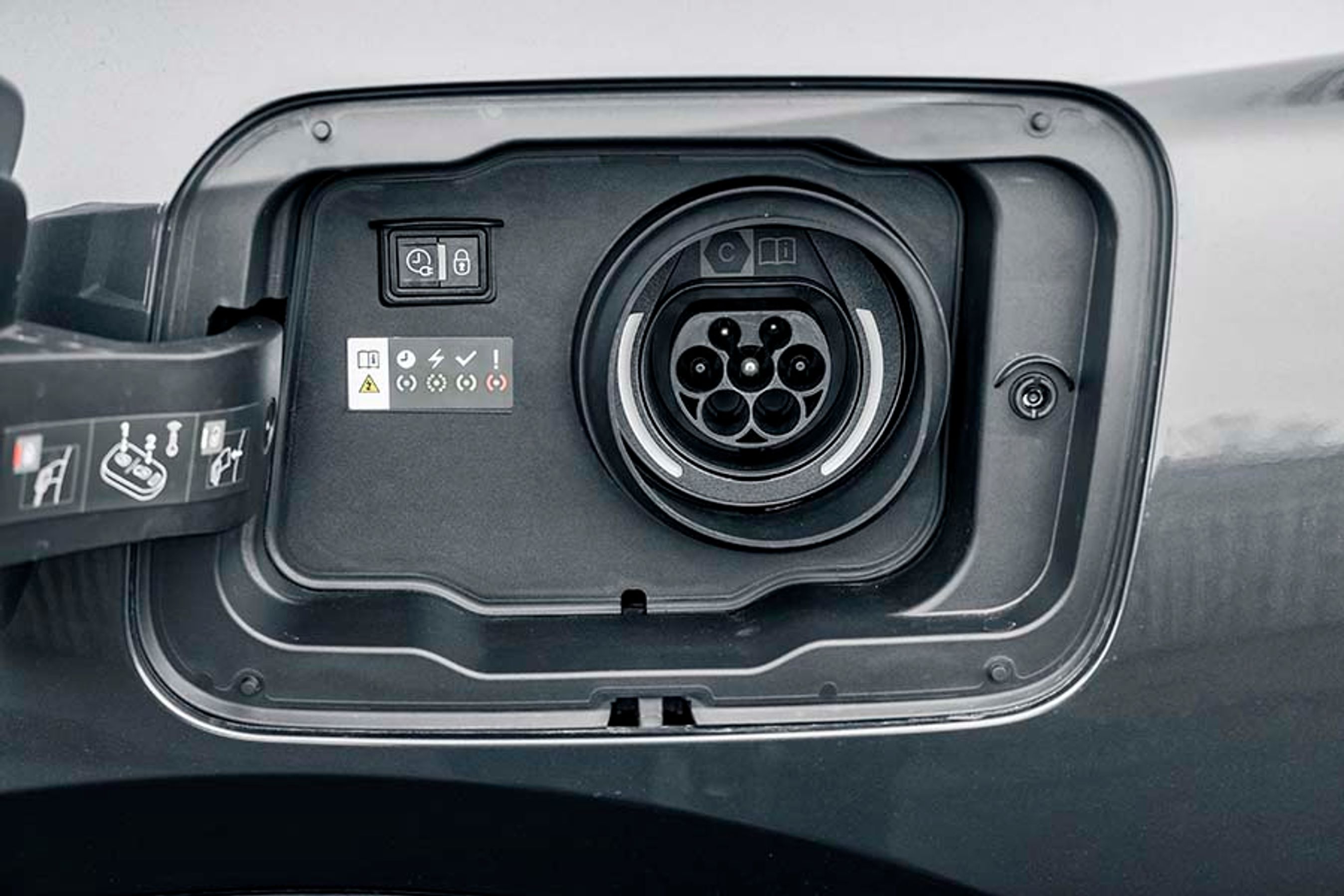 Tankdækslet er placeret i højre side ved baghjulet, mens ladestikket her er placeret i førersiden. Man kan oplade bilen med én fase og 3,7 kW. Ladestikket er flot tætnet, så man slipper for irriterende gummipropper.