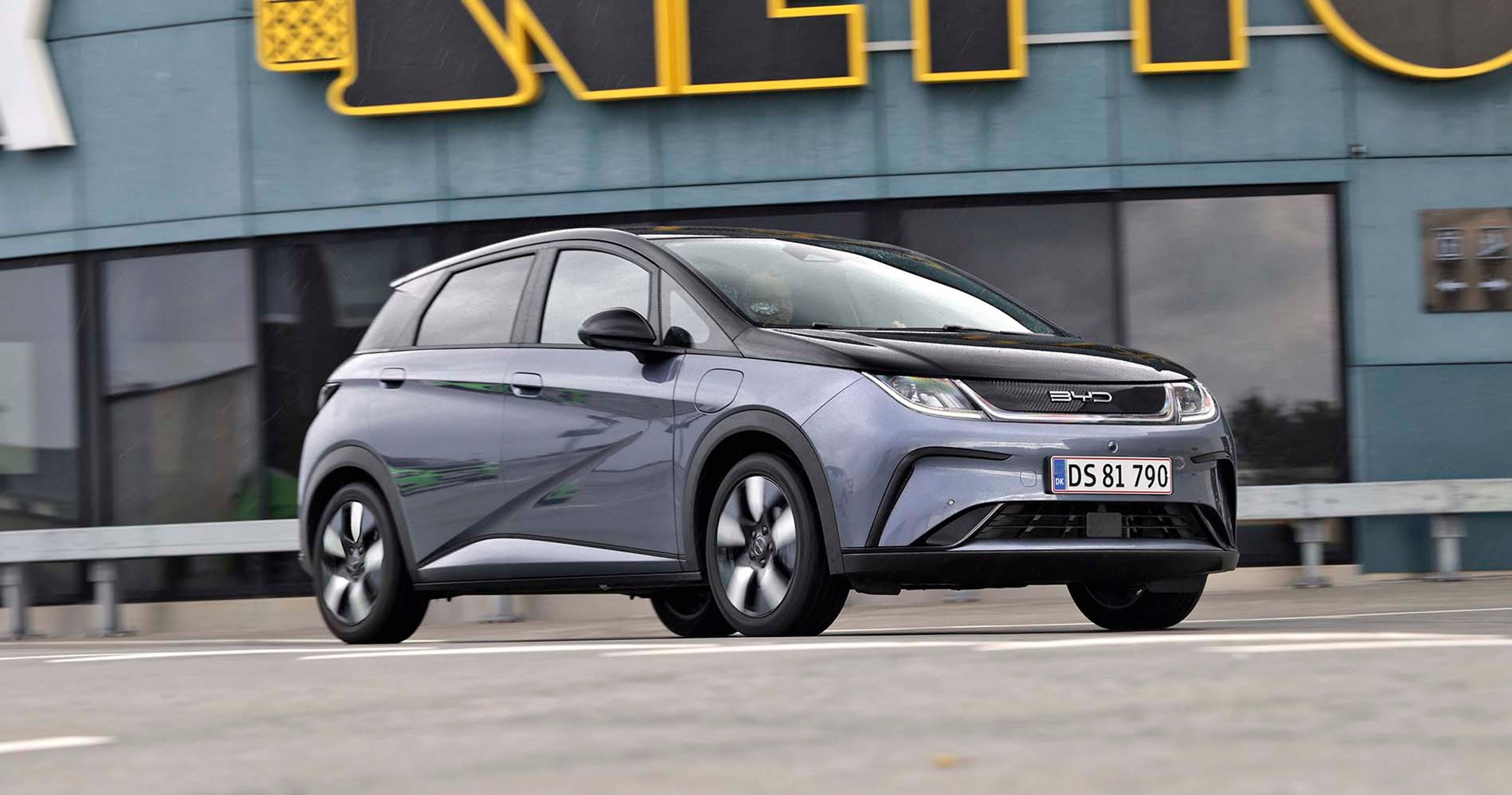 Den billige elbil BYD Dolphin holder foran en Netto-butik.