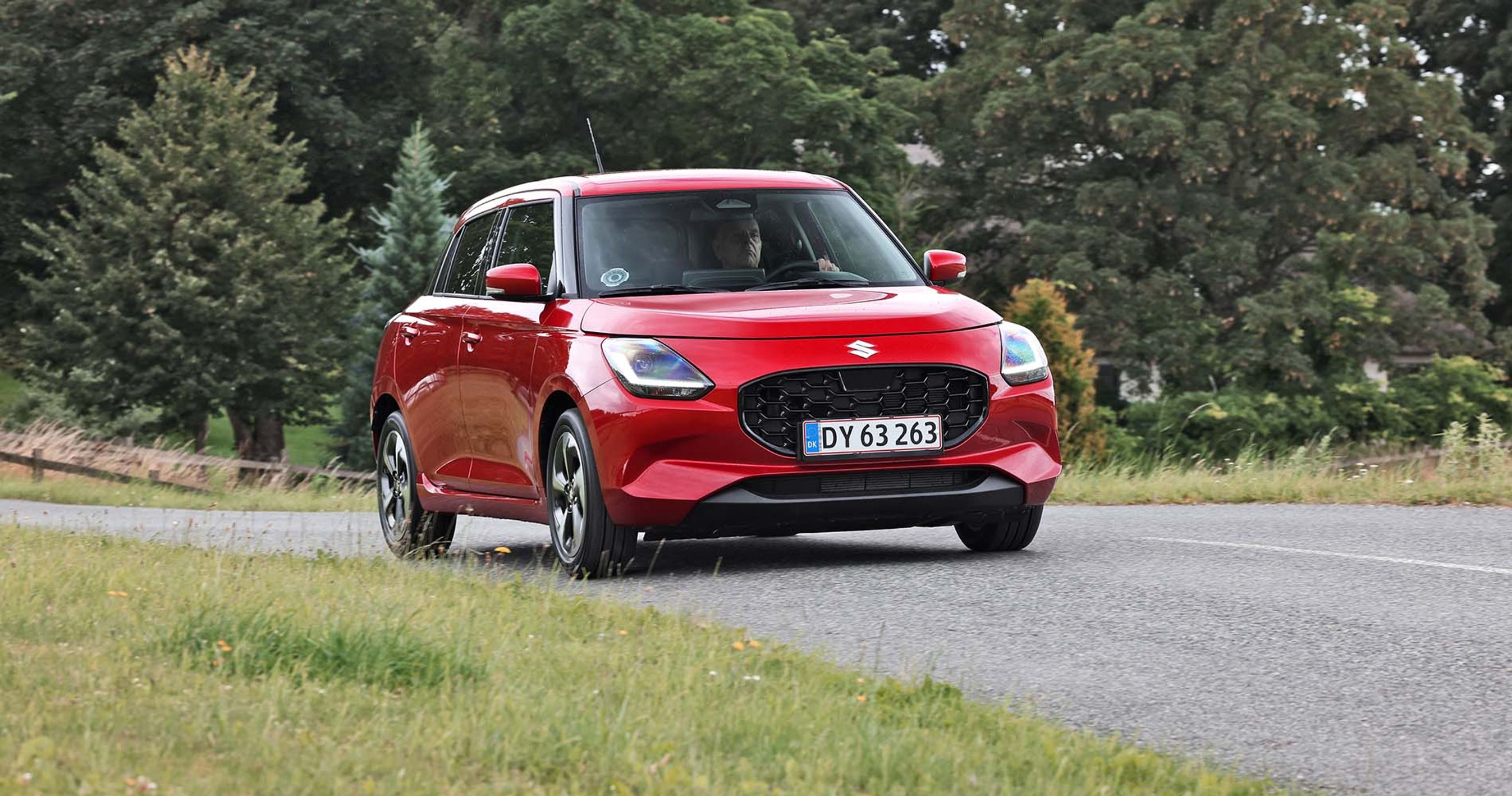 Rød Suzuki Swift kører på vej