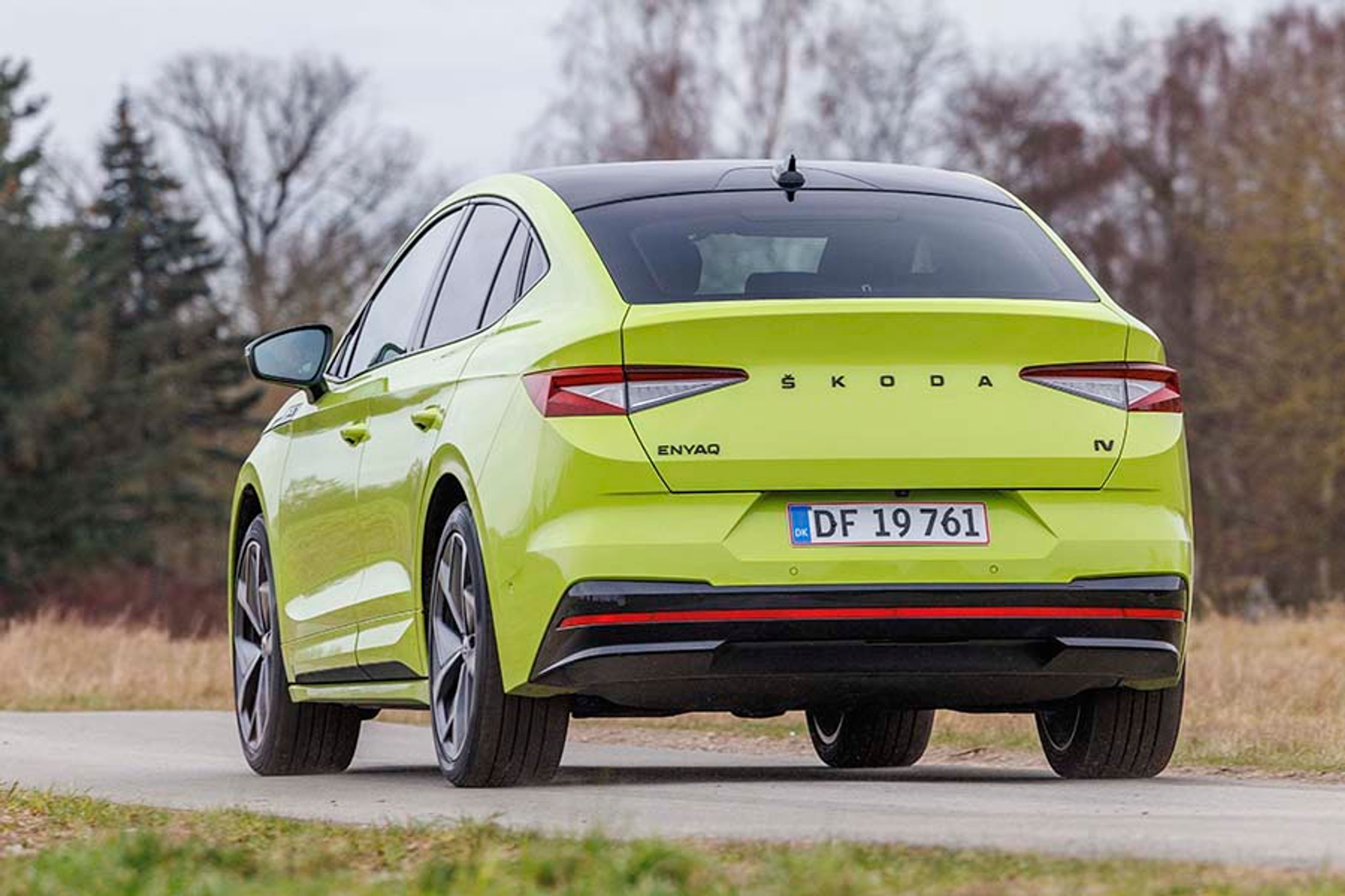 Skoda Enyaq Coupé RS set bagfra. Kører på landevej med træer i baggrunden