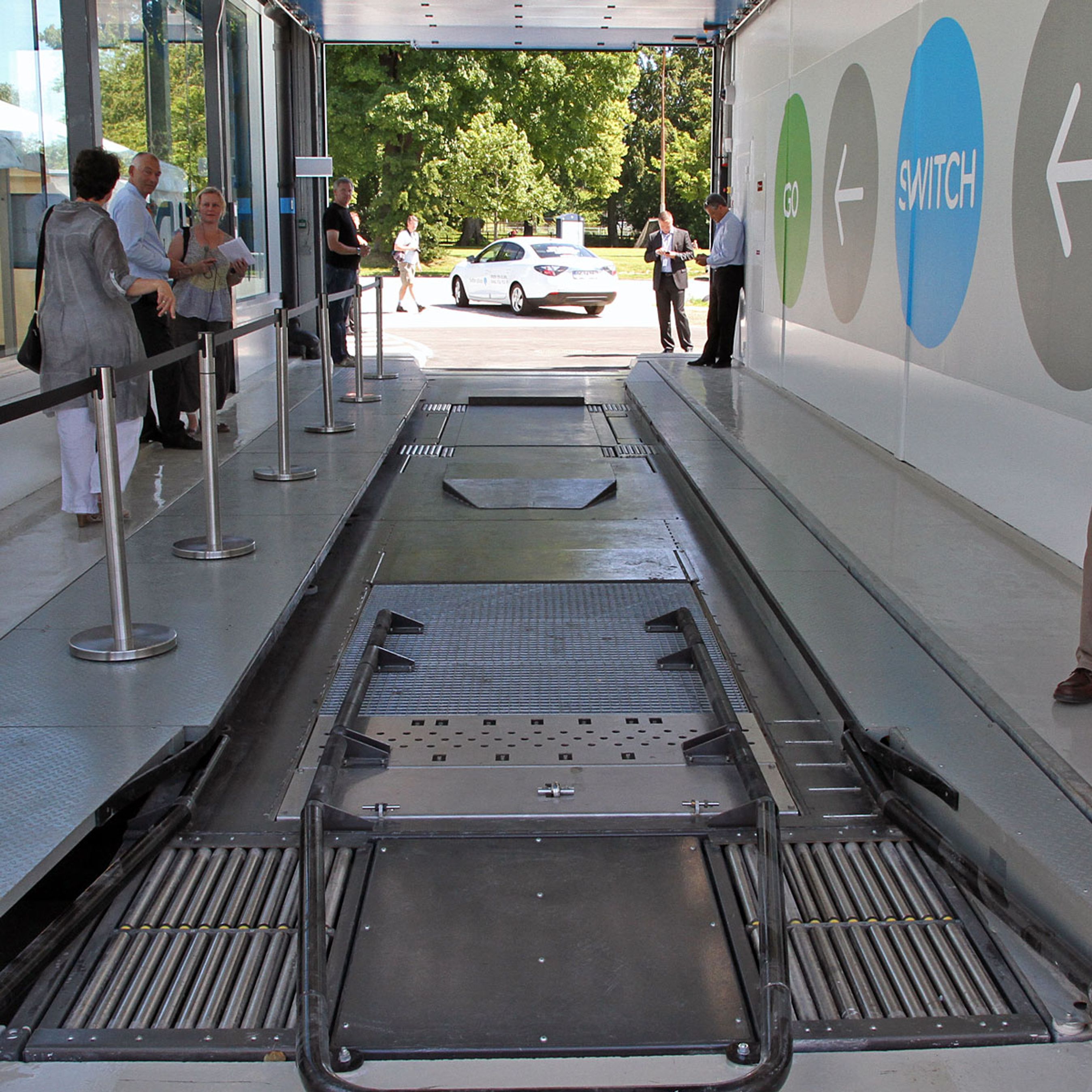 Et kik ind i skifethallen. Bilen standses på den forreste platform. Her vaskes undervognen eventuelt, og herfa trækkes bilen automatisk hen til positionen i det fjerne. Der åbner en lem sig i gulvet, så robotten kan komme til.