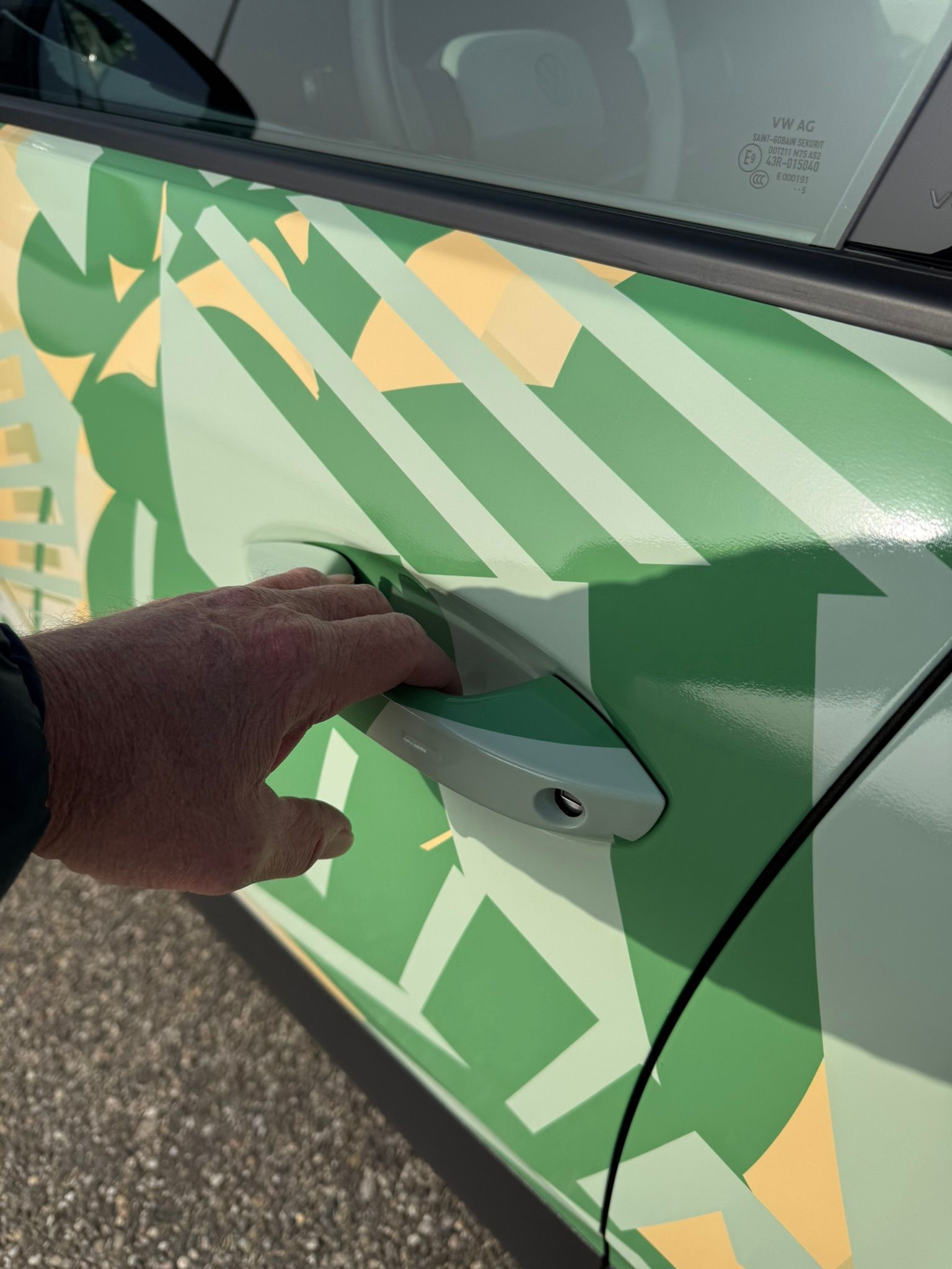 Hånd tager i håndtaget i fordøren på en VW ID. Cross