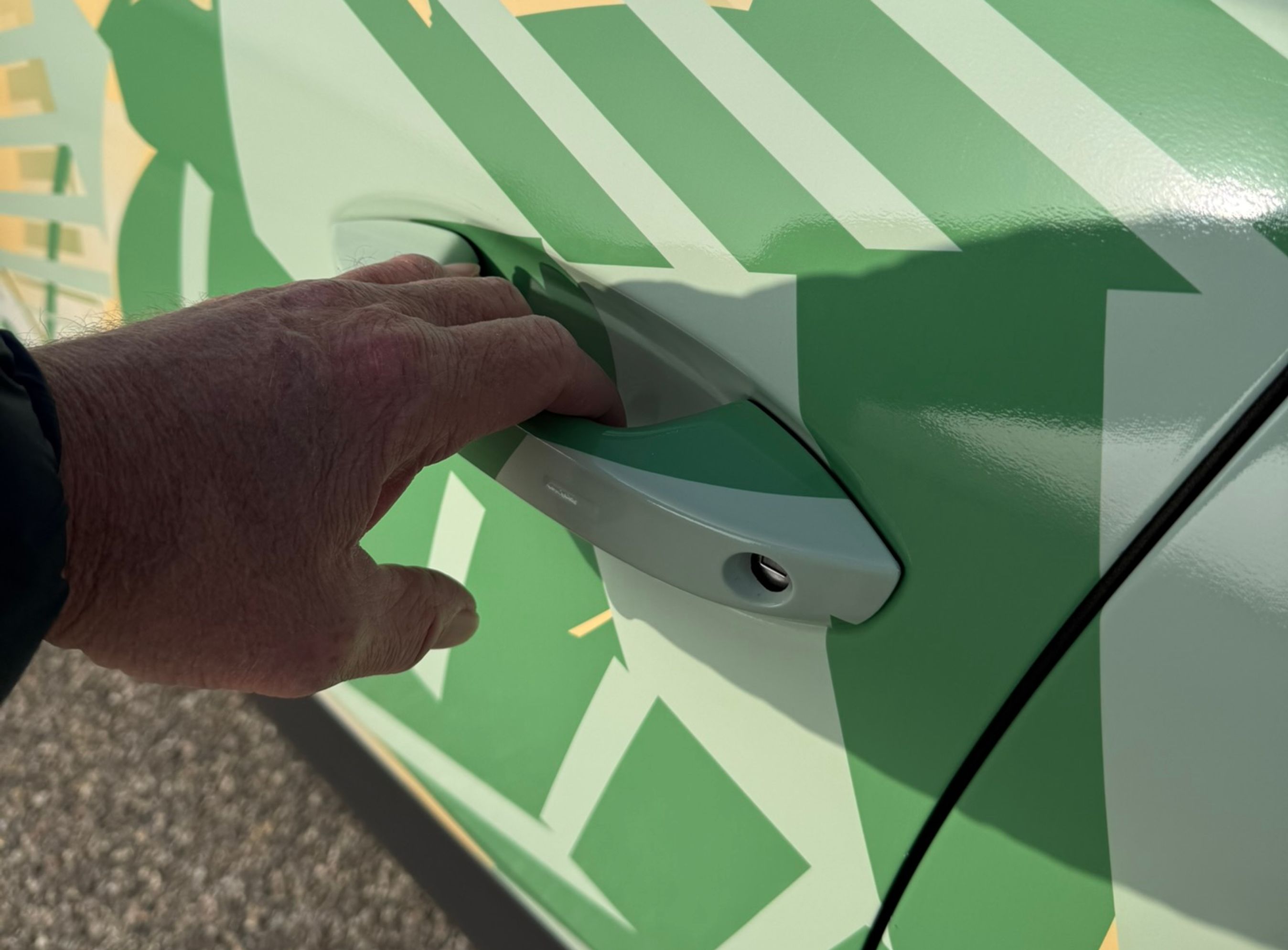 Hånd tager i håndtaget i fordøren på en VW ID. Cross