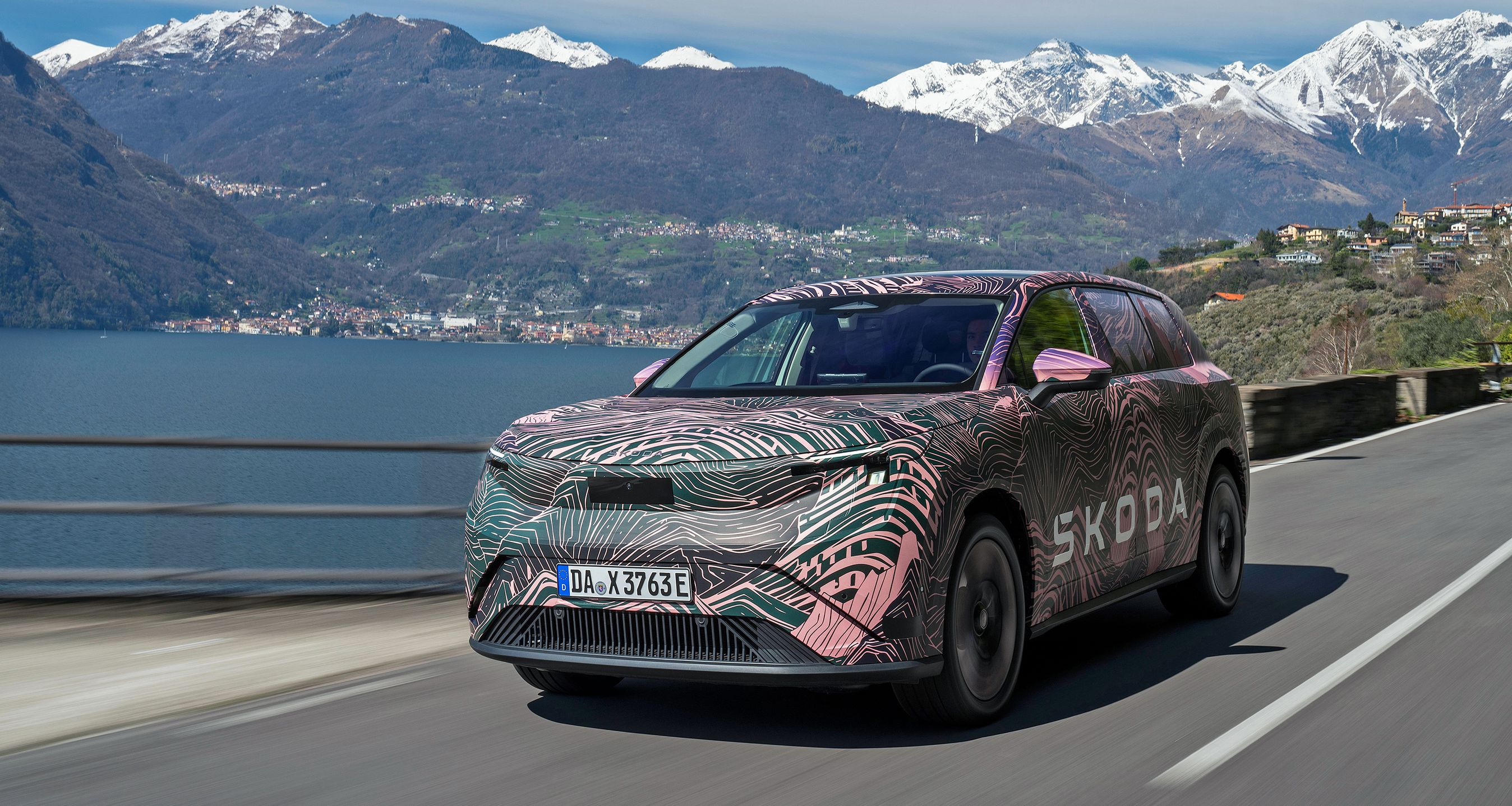 Kamufleret stor SUV kørende med bjerge i baggrunden.