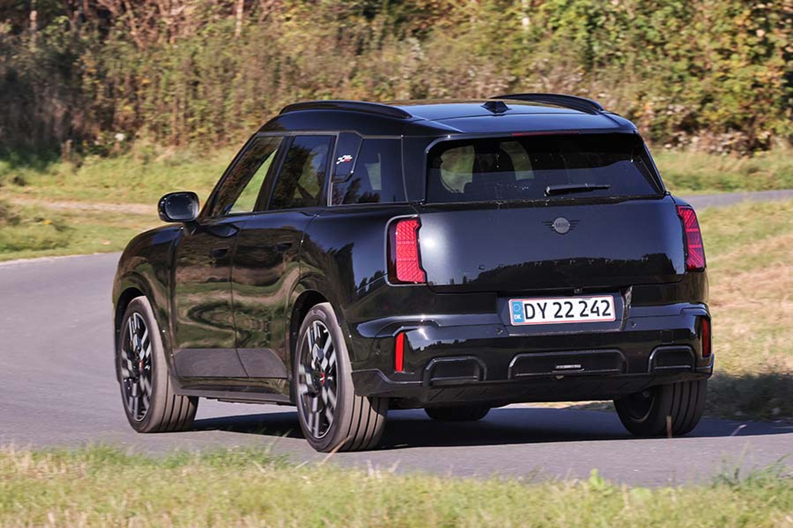 Mini Countryman set bagfra, mens den kører i et sving på en landevej