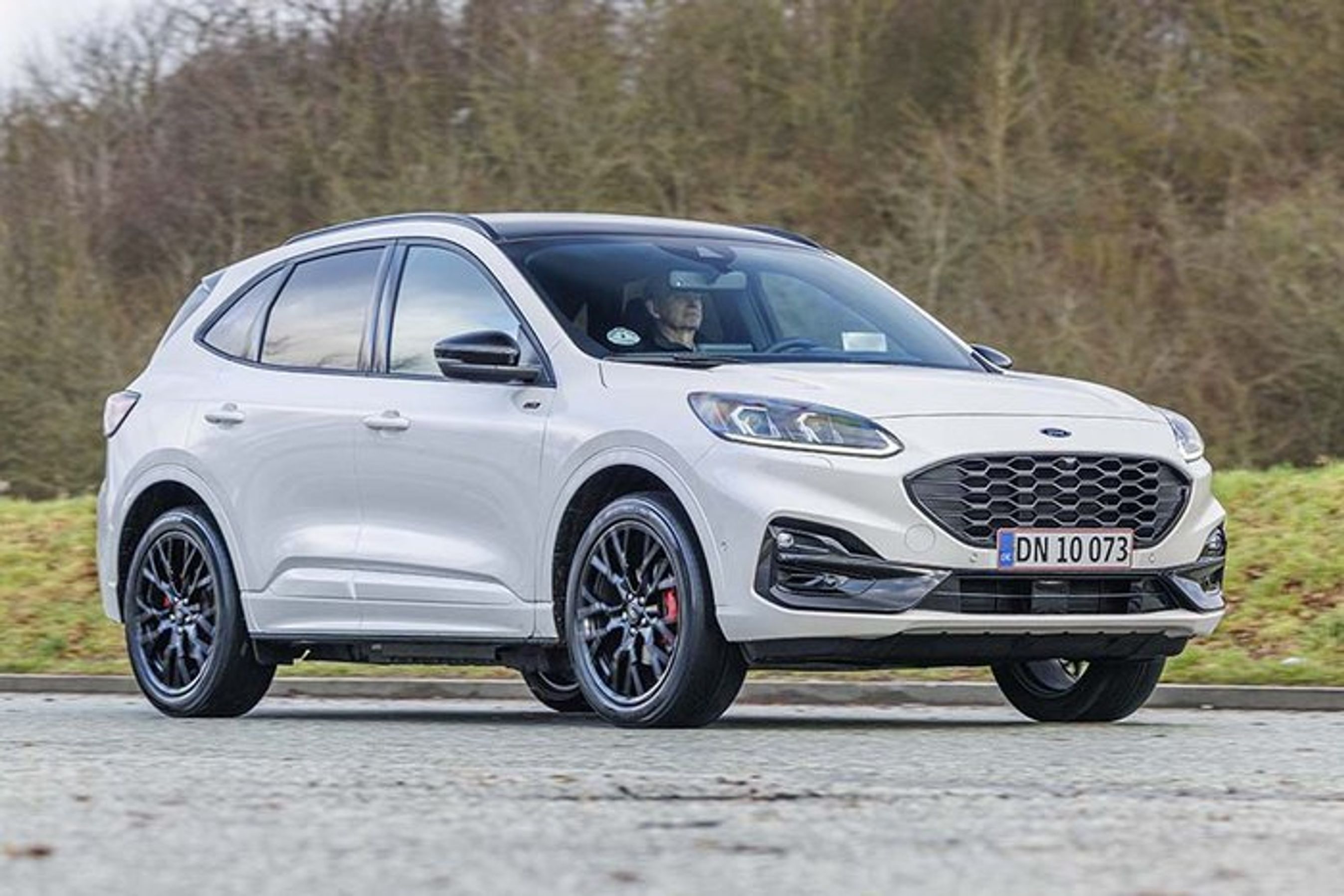 Ford Kuga kører på landevej med træer i baggrunden