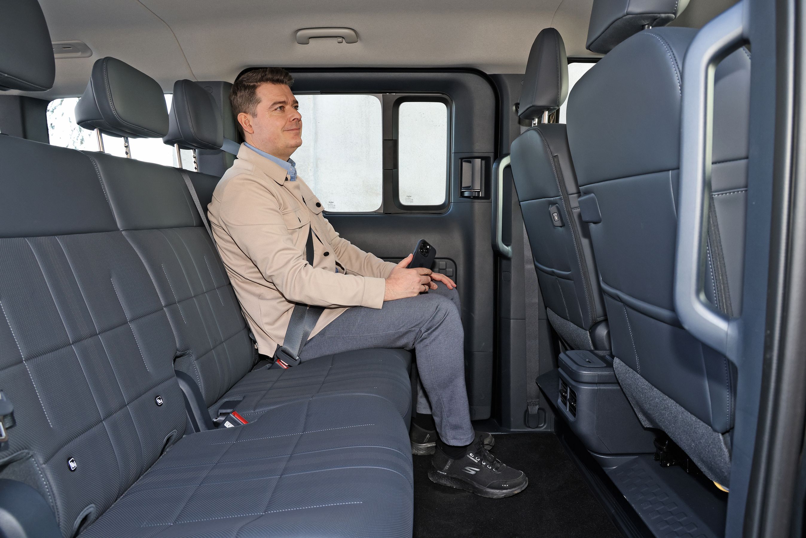 Person sidder på bagsædet i en Kia PV5