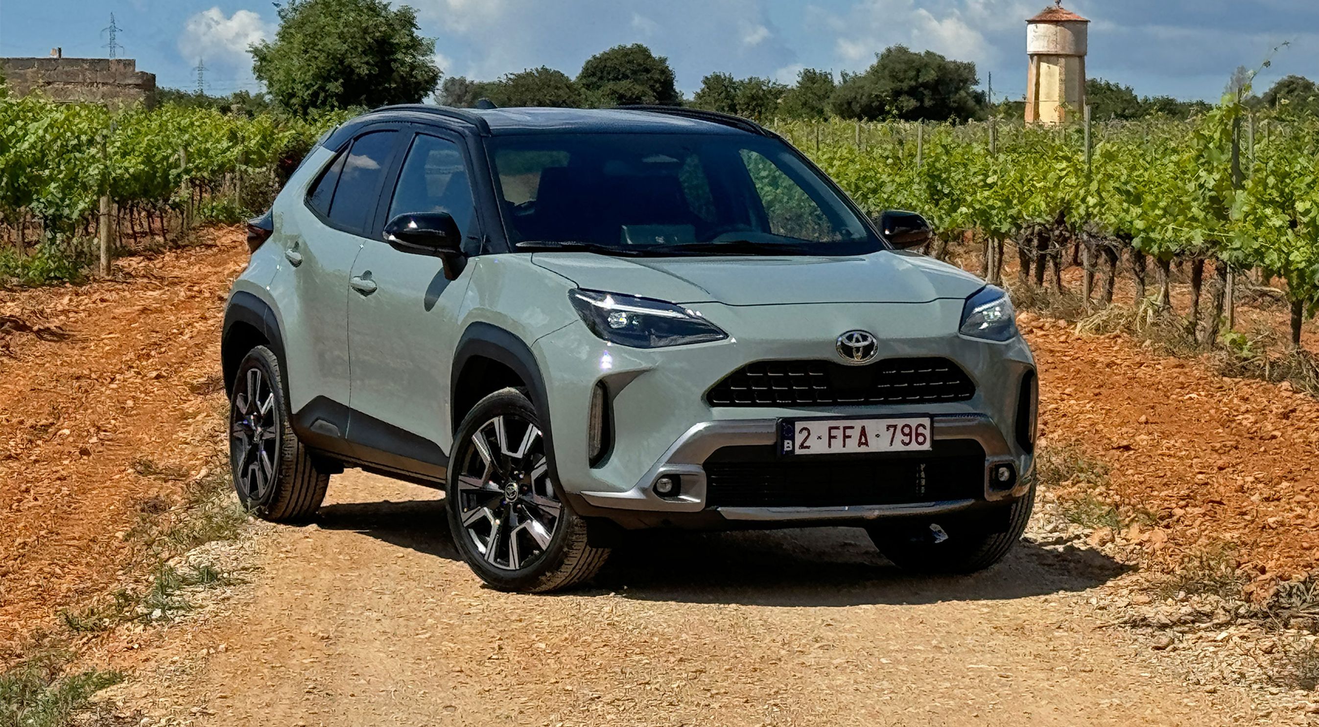 Toyota Yaris Cross holder på en grusvej med vinmarker rundt om