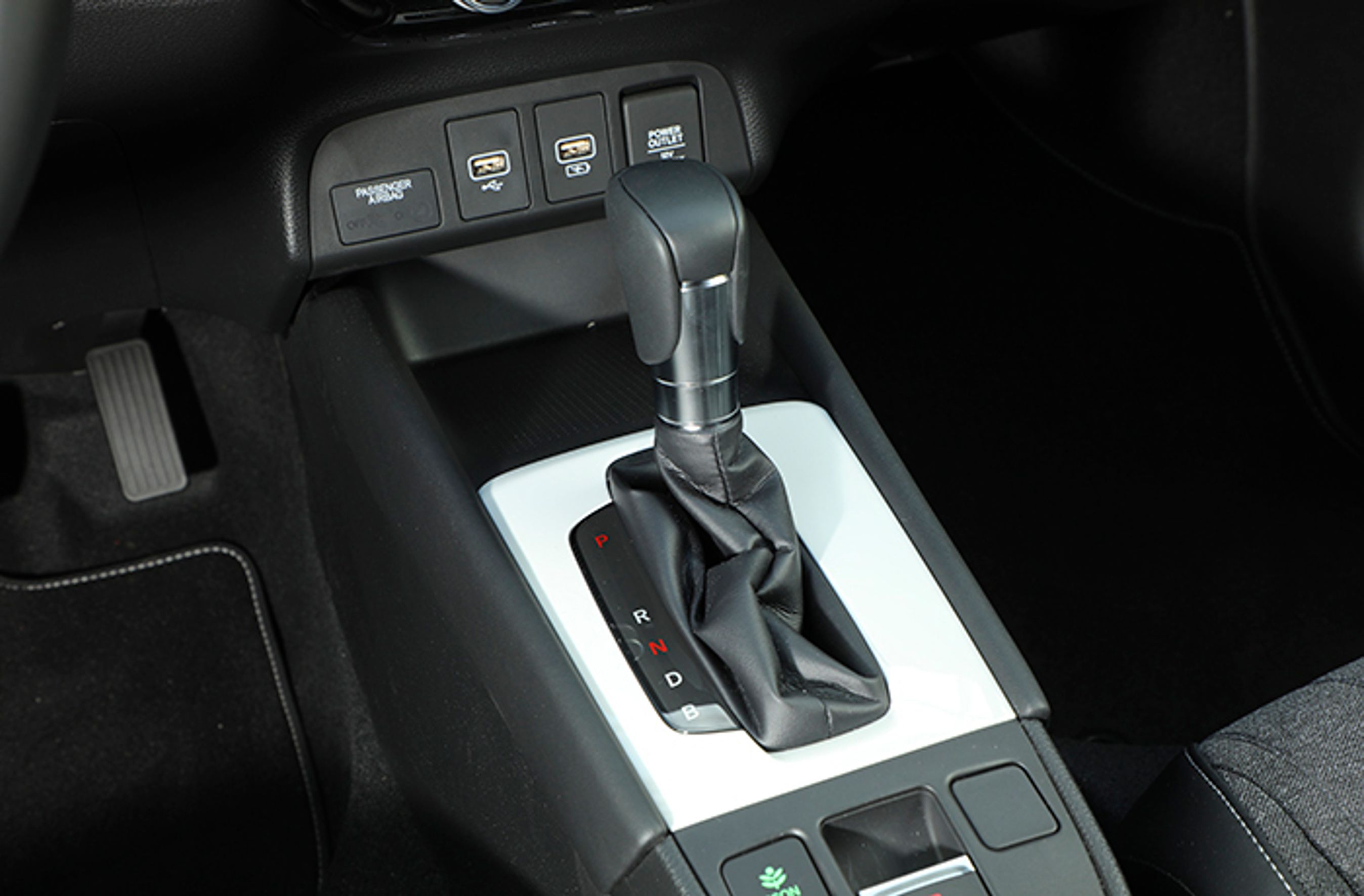 Gearstangen er af den mekaniske type, og skal sættes i P, før motoren stoppes. Foran den er der usb-stik og et pænt opbevaringsrum, men vi savner trådløs opladning af mobiltelefonen.