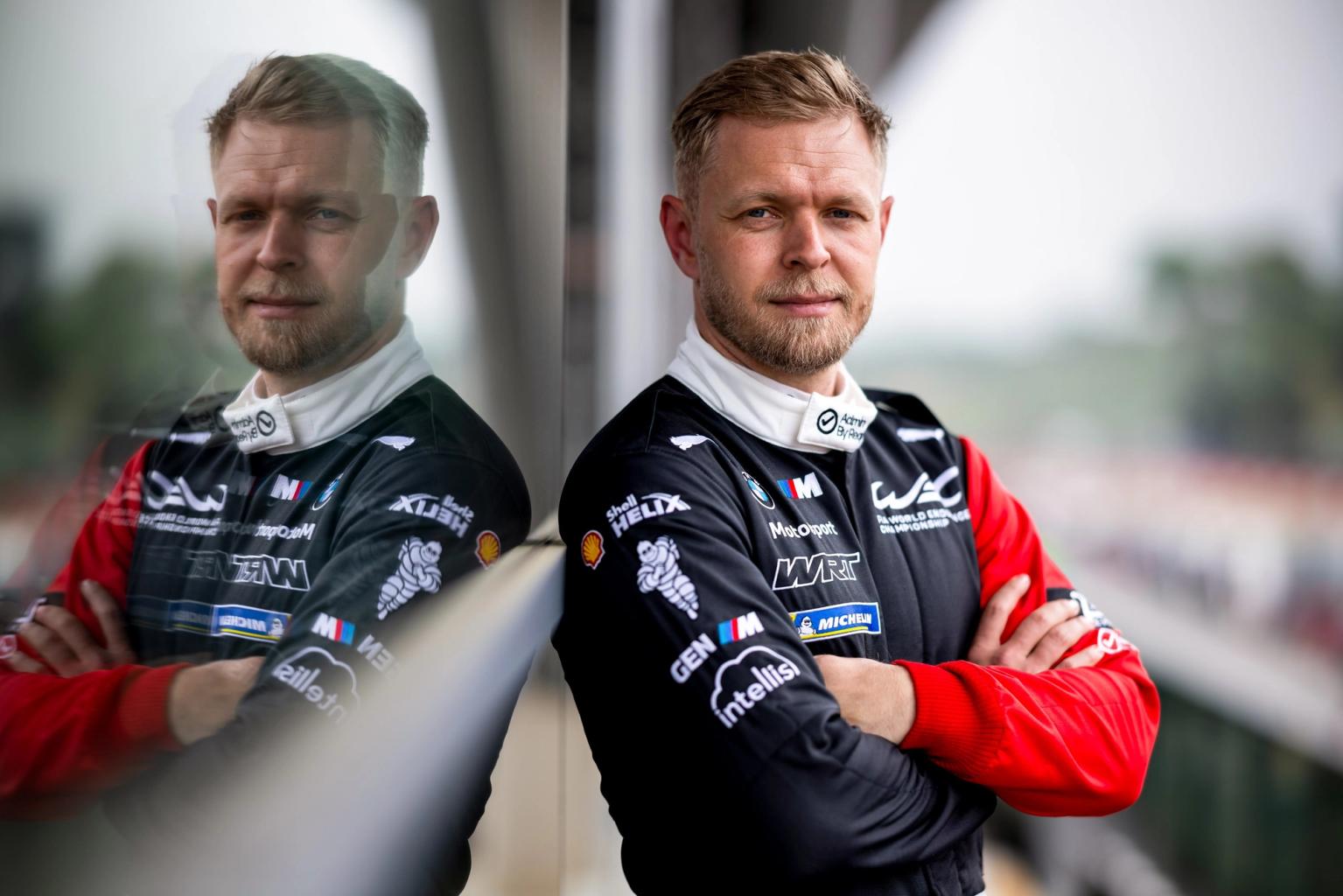 Kevin Magnussen poserer ved vindue i racerudstyr