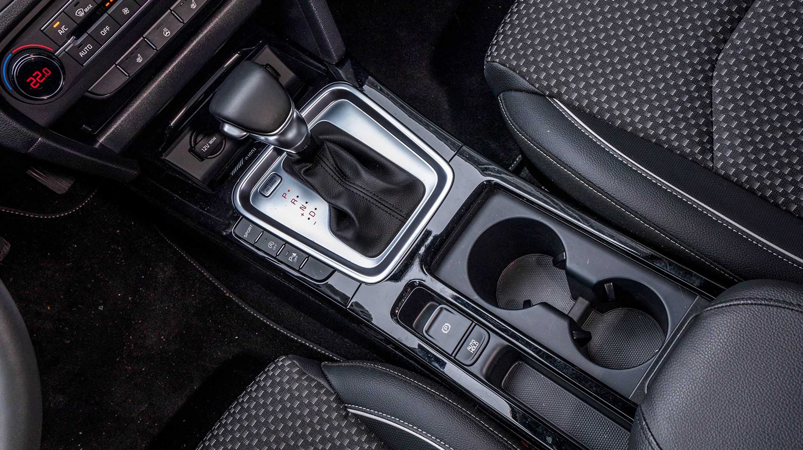 Fralægningspladsen er forbilledlig. Der er en mobilhylde foran gearvælgeren og to rigtig gode kopholdere, der både kan holde på en kaffekop eller en ½ liters vand.  