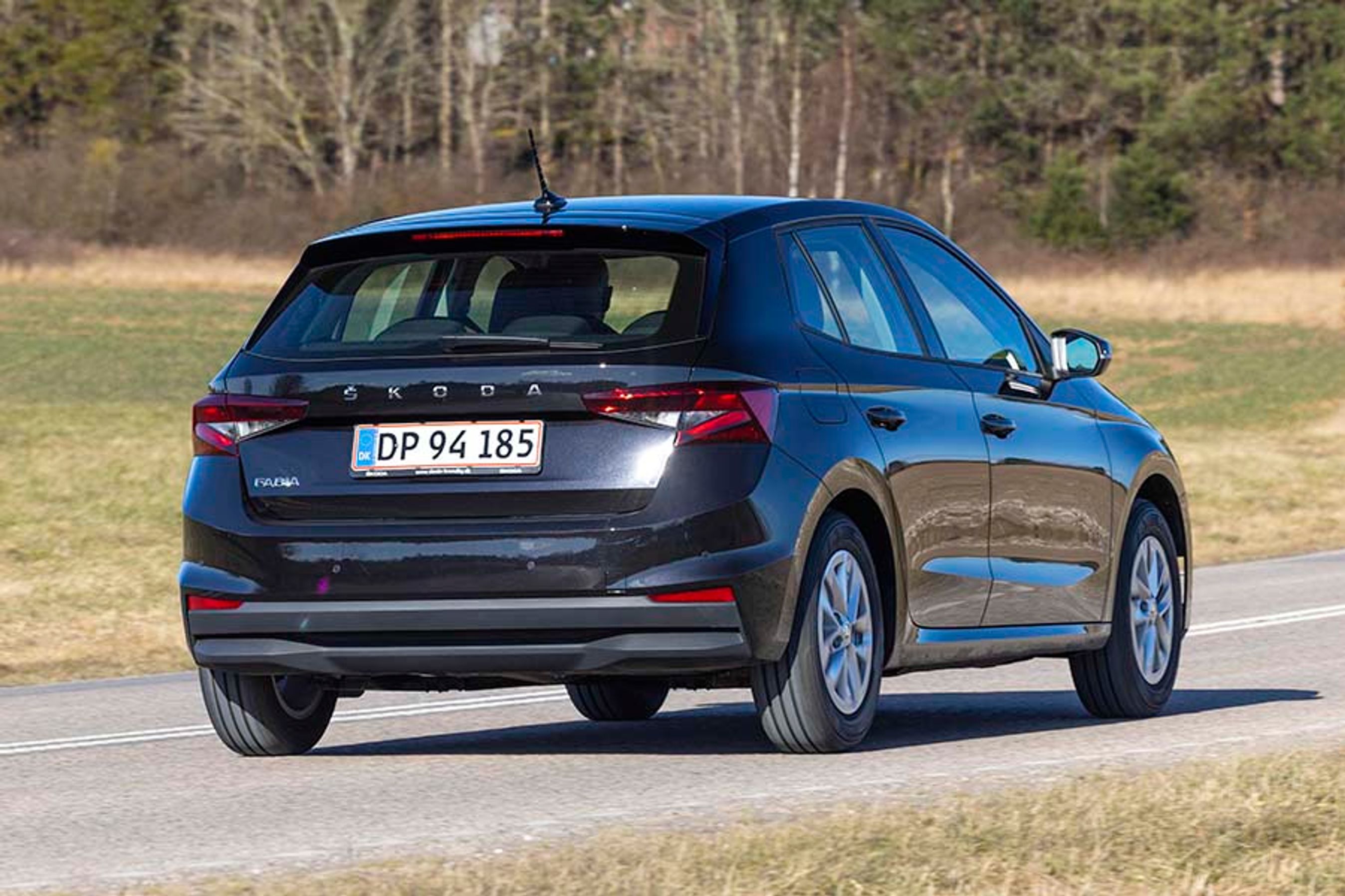 Sort Skoda Fabia set bagfra, mens den kører på en landevej