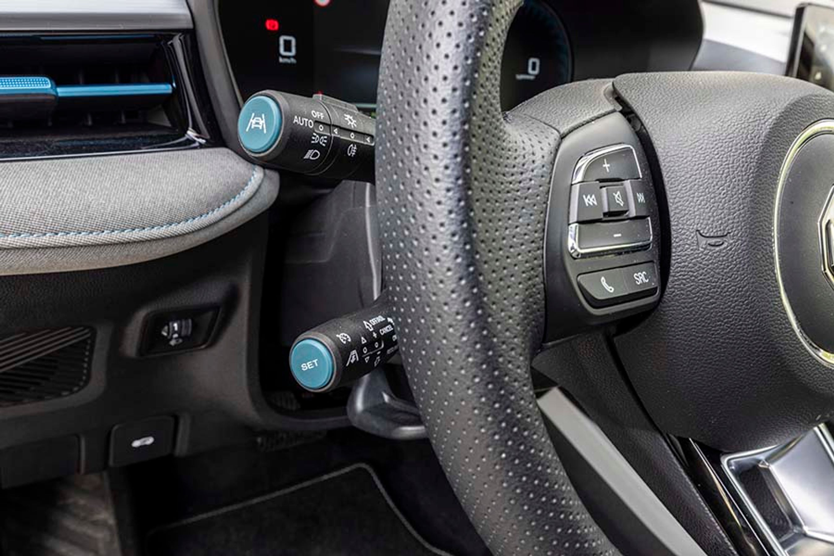 Bag rattet i venstre side sidder en stilk til fartpiloten nederst. Den er let at betjene, når man først har lært den at kende, men i begyndelsen giver den besvær for de uøvede. Øverst kan man koble vognbaneassistenten til og fra ved tryk for enden af stilken. Det er godt!