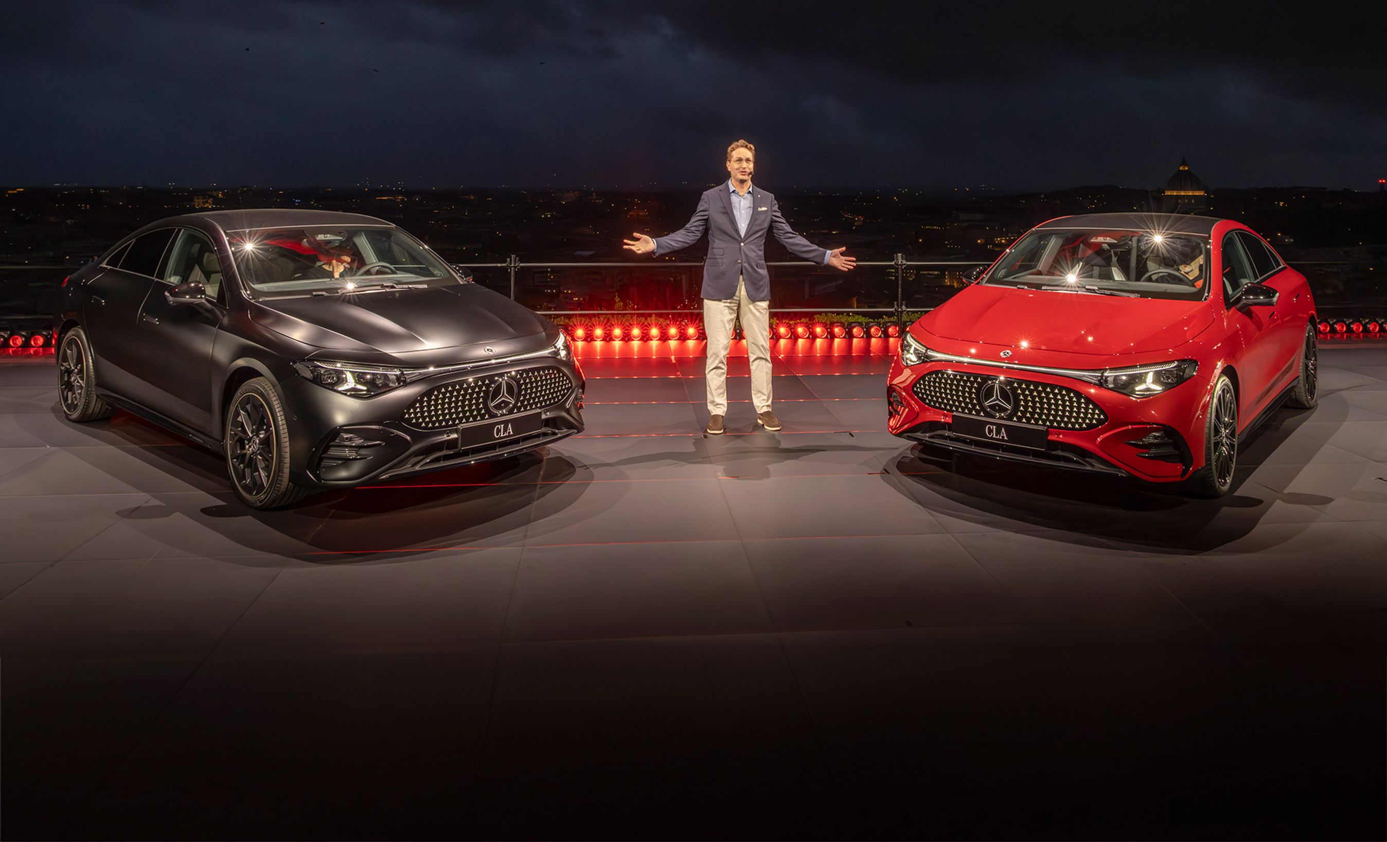 Mand på scene mellem sort og rød Mercedes CLA