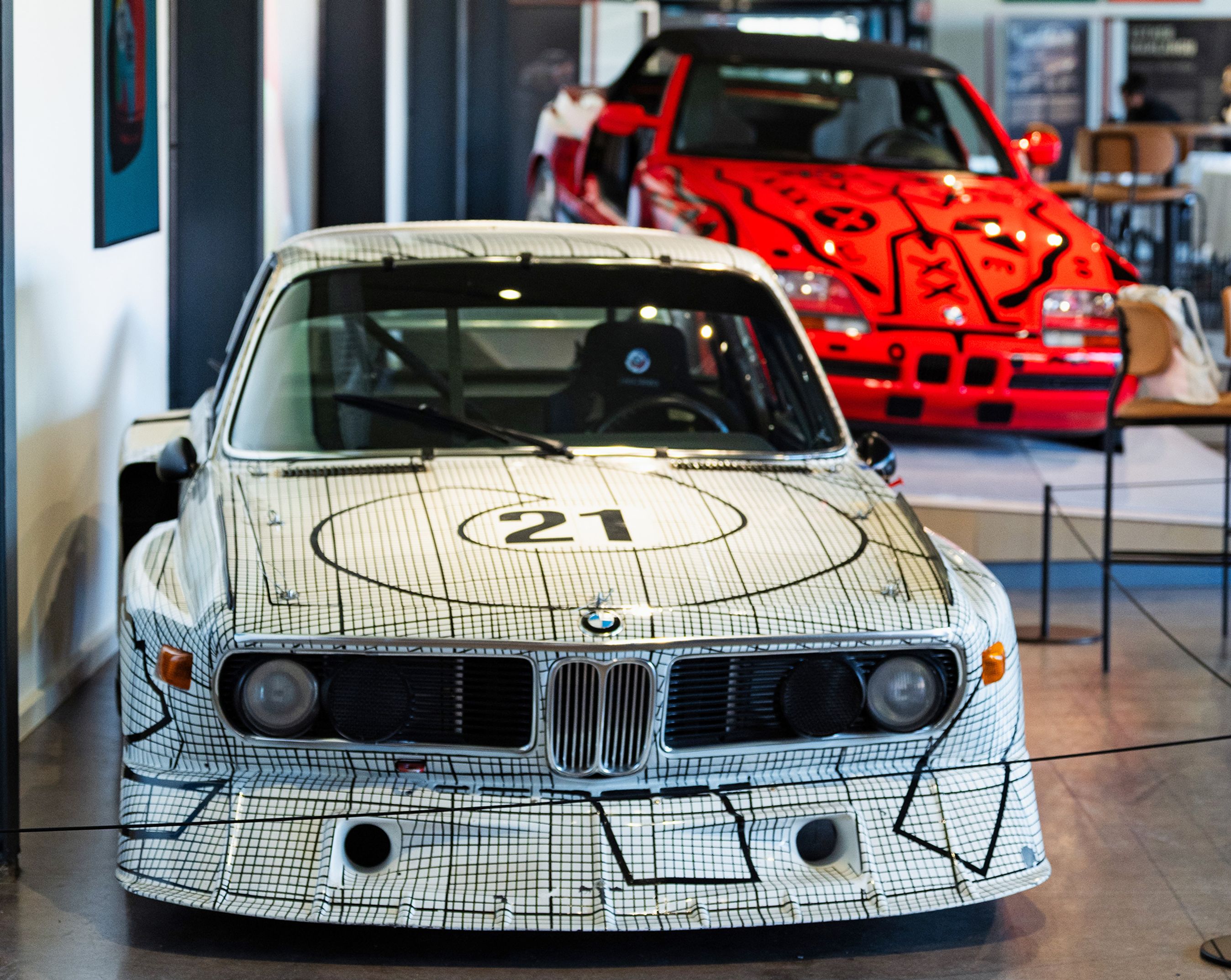 To dekorerede racerbiler, en hvid og en rød.