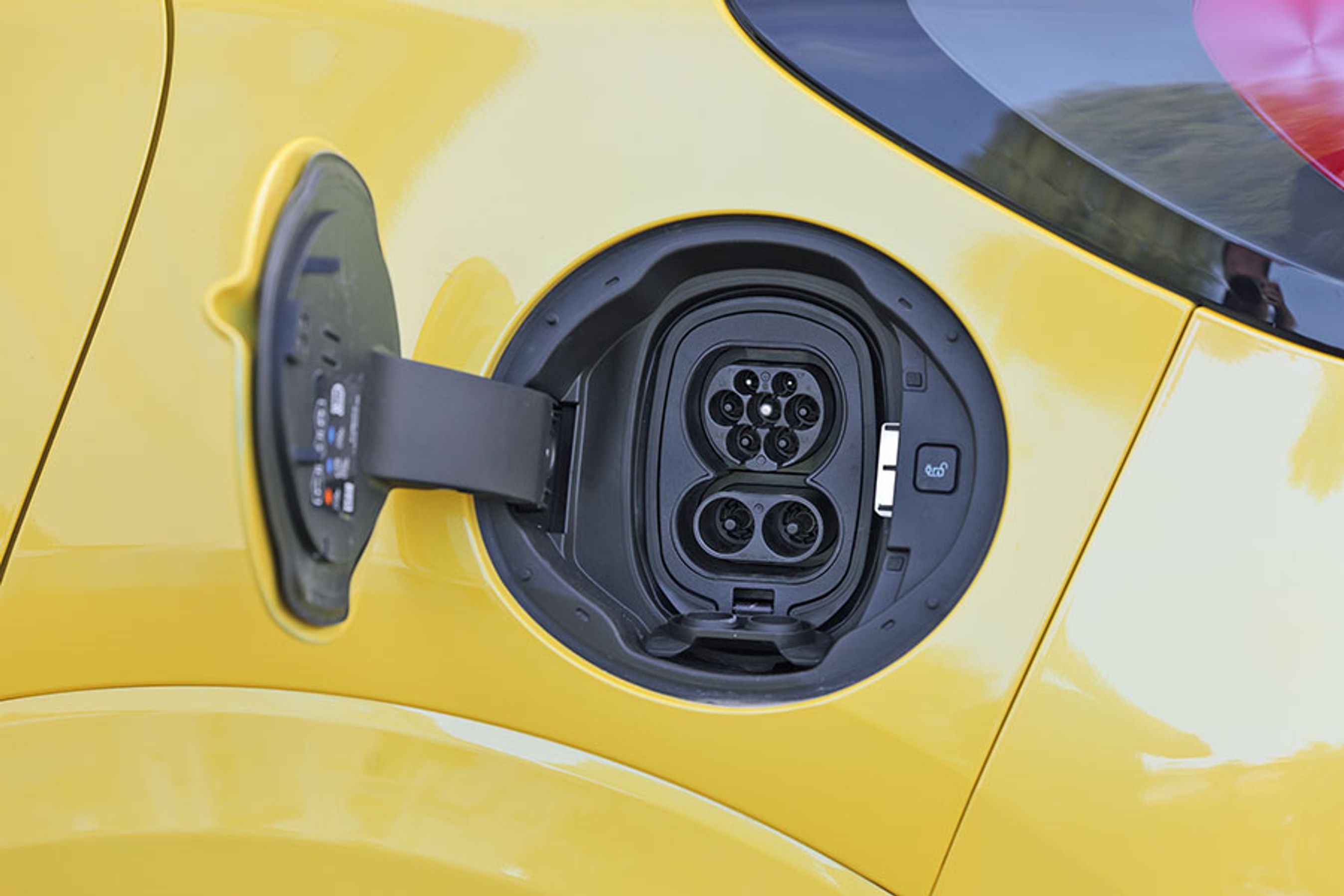 Ladelugen er placeret ved venstre baghjul. Der er mulighed for at lade hjemme med tre faser og 11 kW, og på farten kan man lynlade med op til 100 kW. En knap gør det let at få kablet frigjort, når man skal videre.