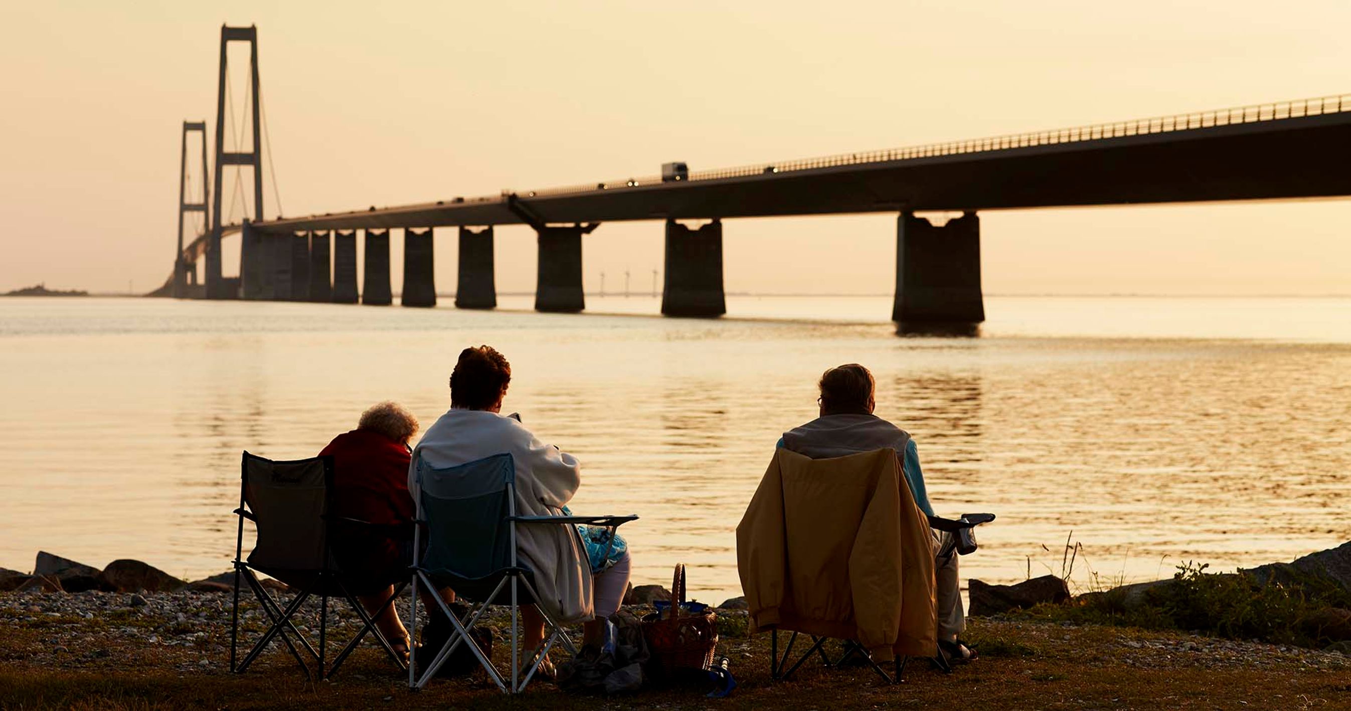 Mennesker ser på solnedgang ved Storebæltsbroen