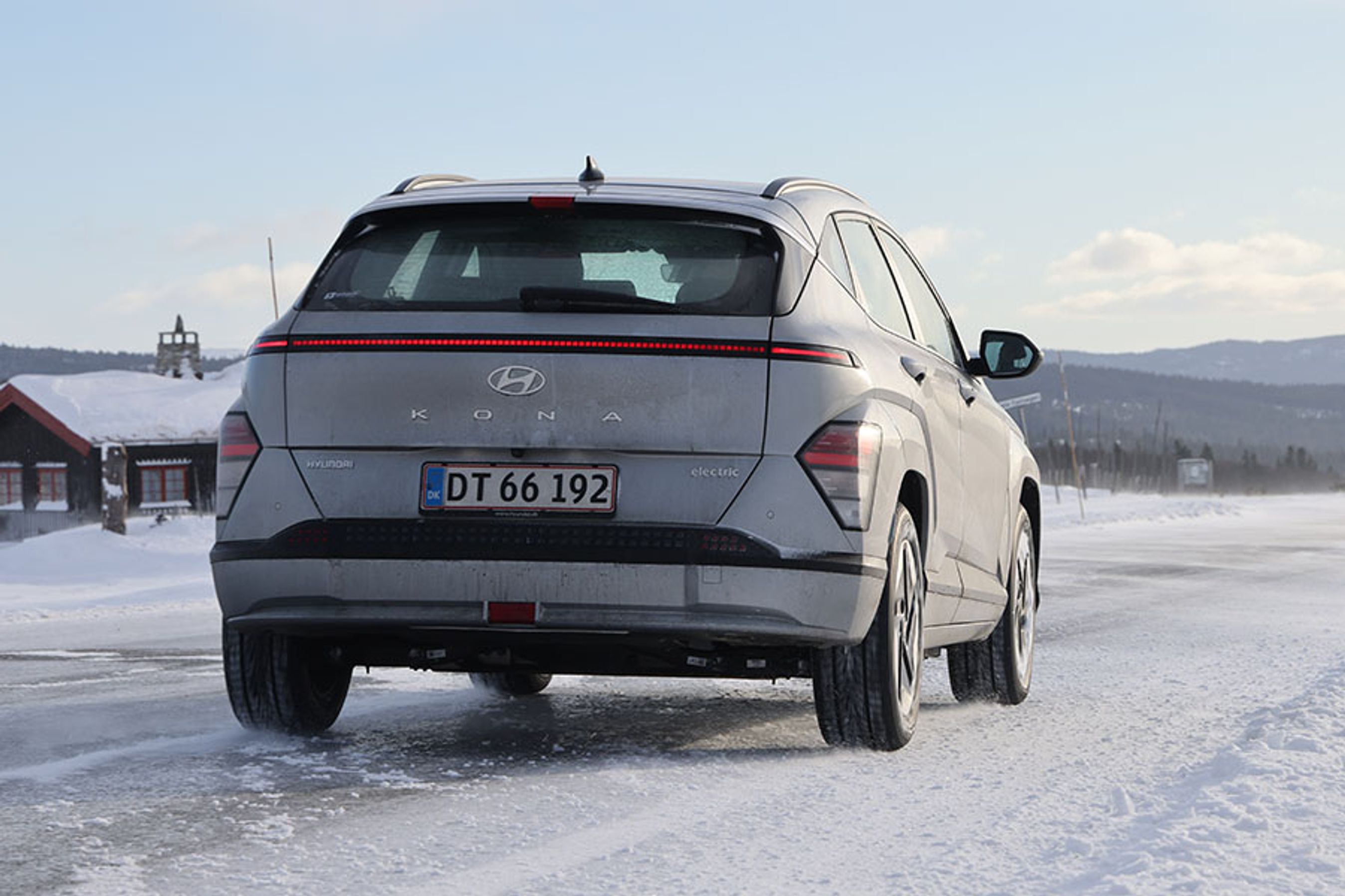 Hyundai Kona set bagfra, mens den holder på en snedækket vej