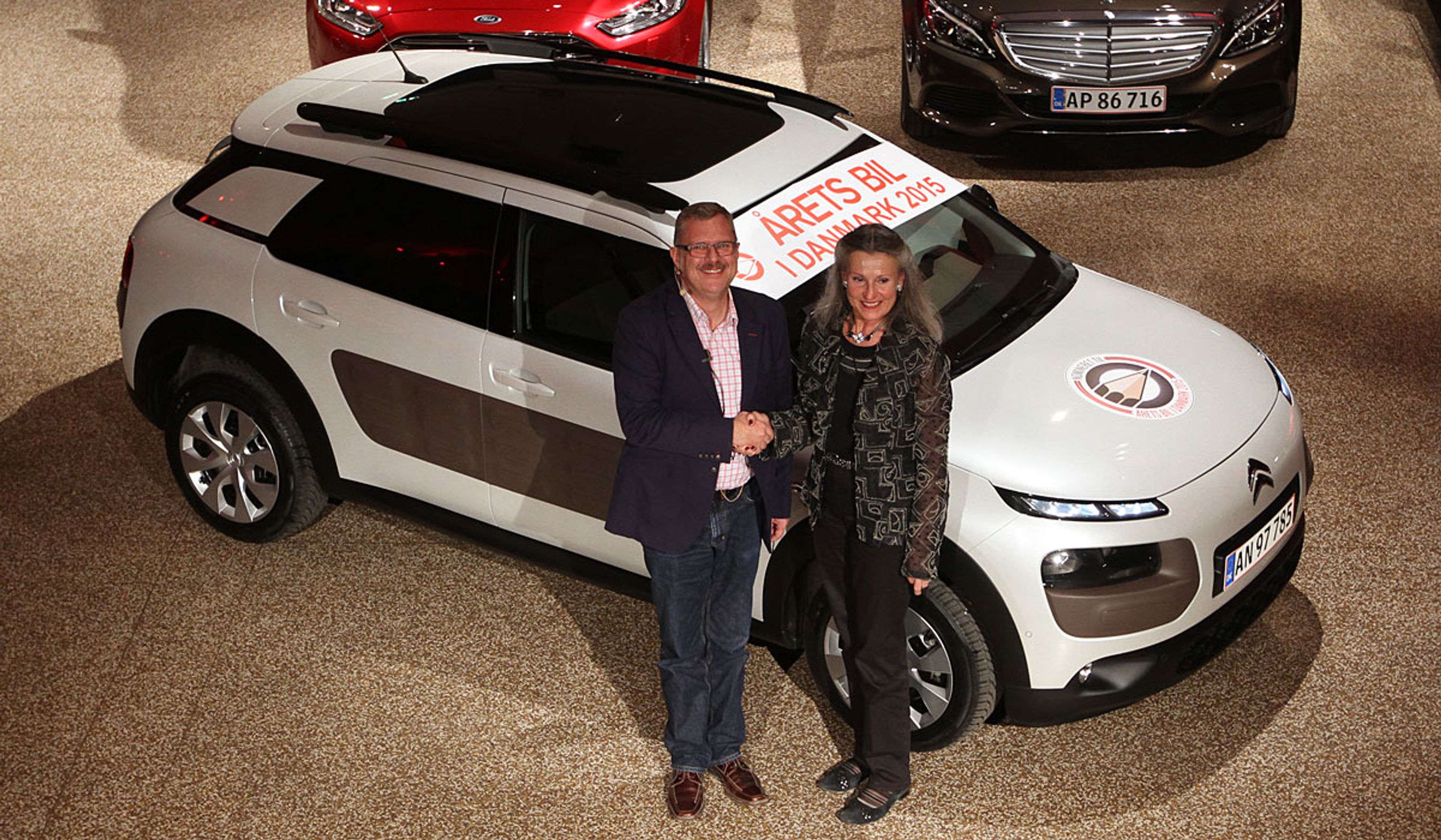 Formanden for motorjournalisterne, Mikkel Thomsager, lykønsker Ellen Nørregaard, Citroën, med sejre.