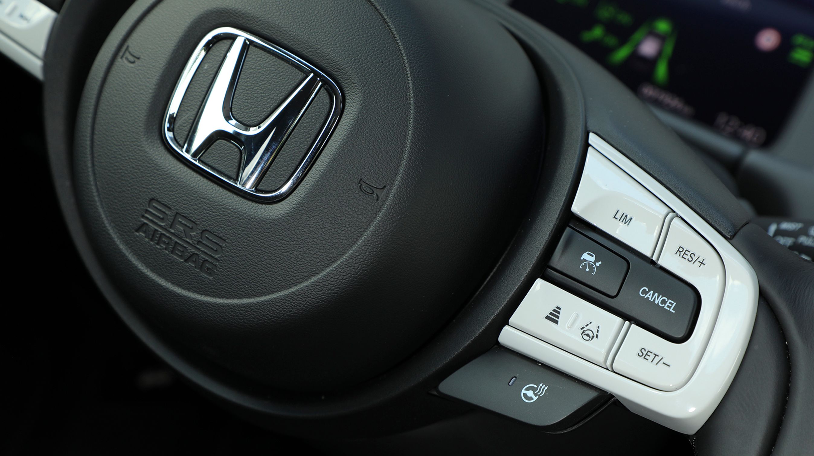 Fra rattet styres den adaptive fartpilot, og der er tilmed en ganske velfungerende vognbaneassistent, der fastholder bilen i vognbanen. Bemærk også kontakten til at tænde for varmen i rattet.