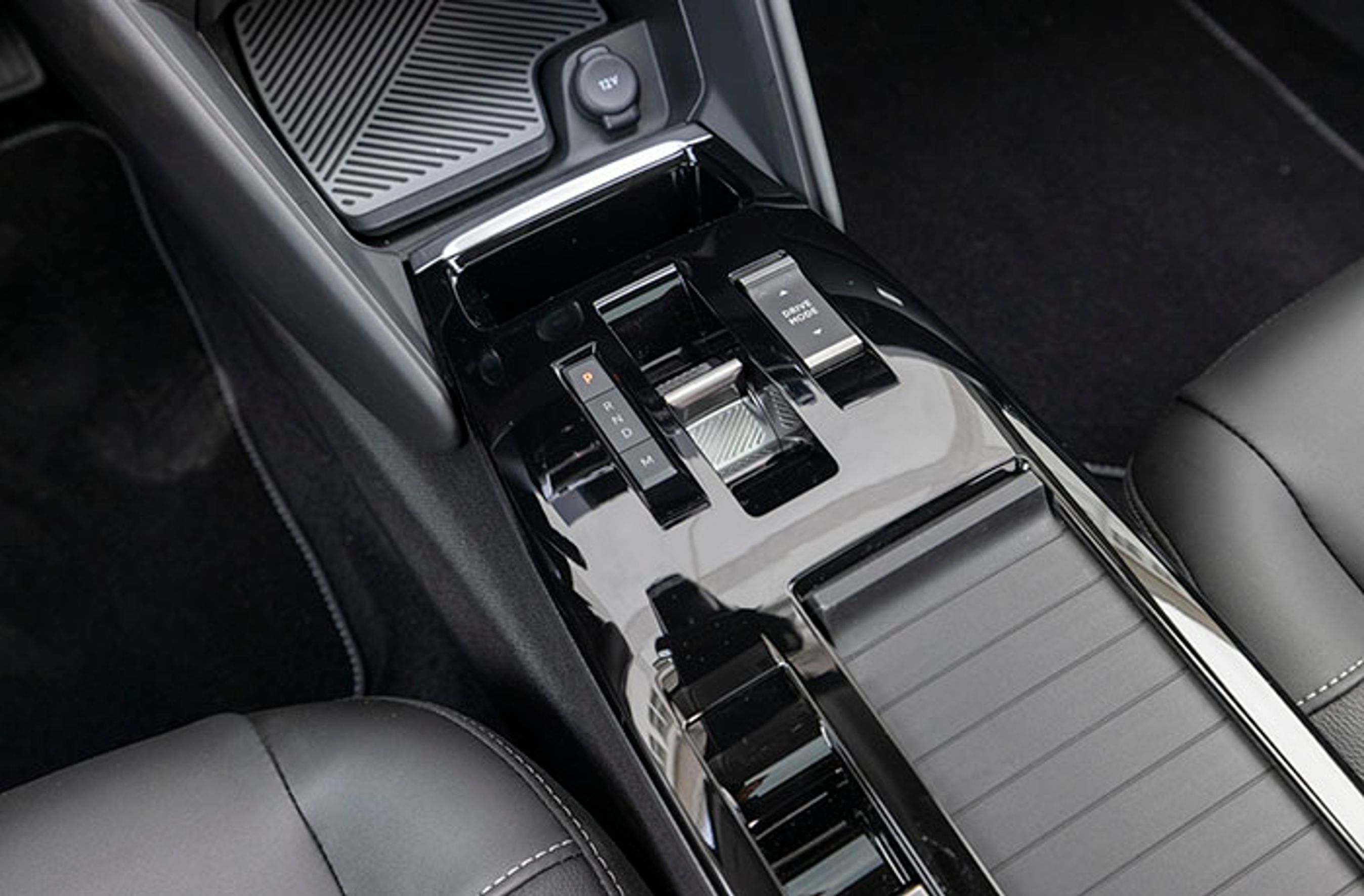 Automatgearet er med otte trin og styres fra denne lille vippeknap mellem forsæderne. Fra knappen til højre vælger man mellem tre køreprogrammer: Eco, Normal og Sport. Foran gearvælgeren er der trådløs opladning af mobilen.