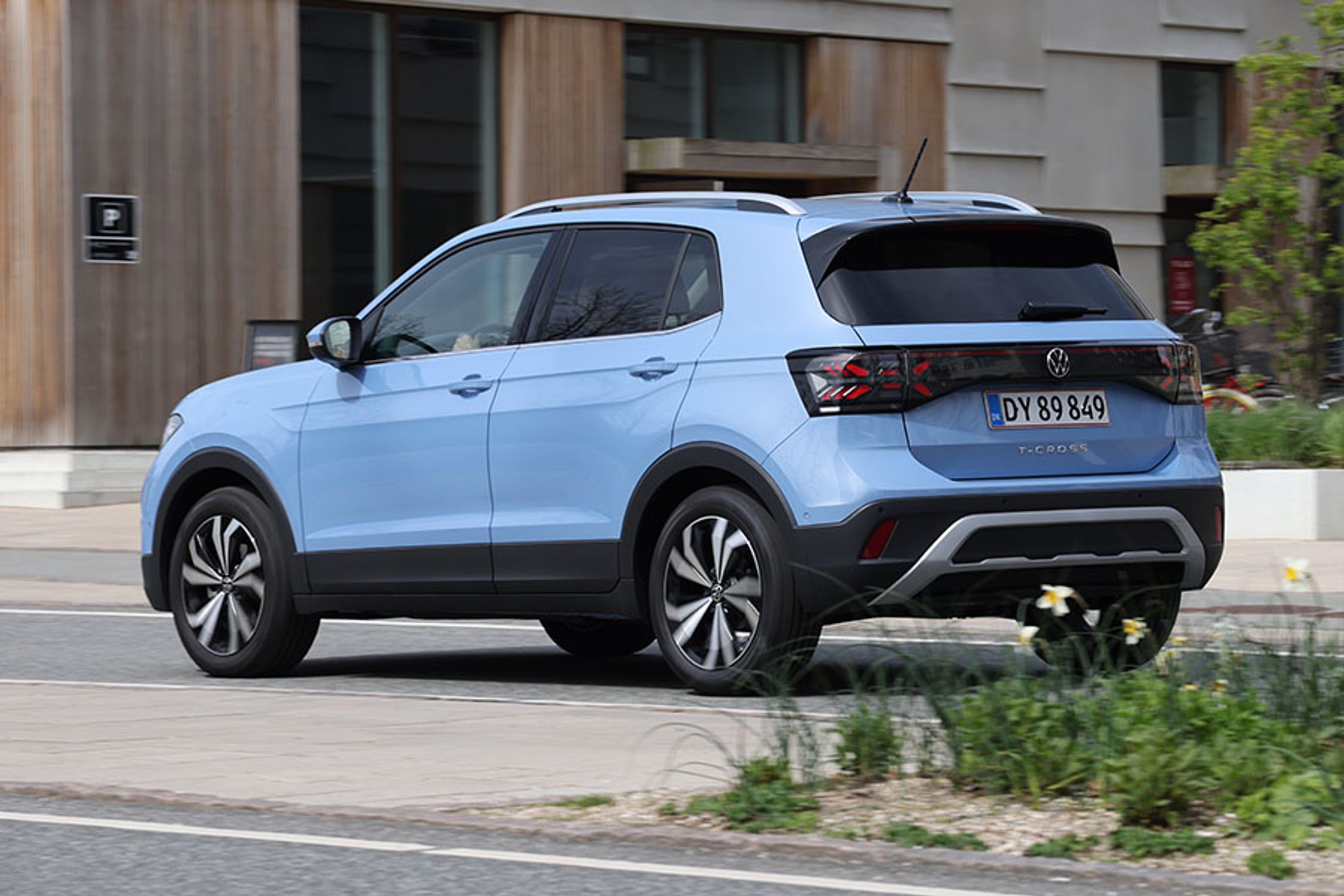 Blå VW T-Cross set bagfra, mens den kører i en by