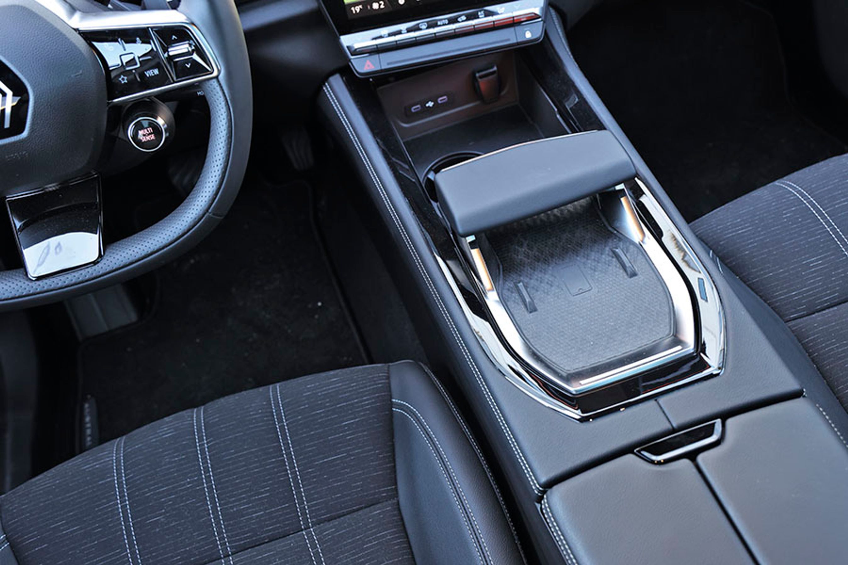 I midterkonsollen er der trådløs opladning af mobiltelefonen. Det store greb bruges dels til at åbne for rummet nedenunder, dels til at hvile armen på. 