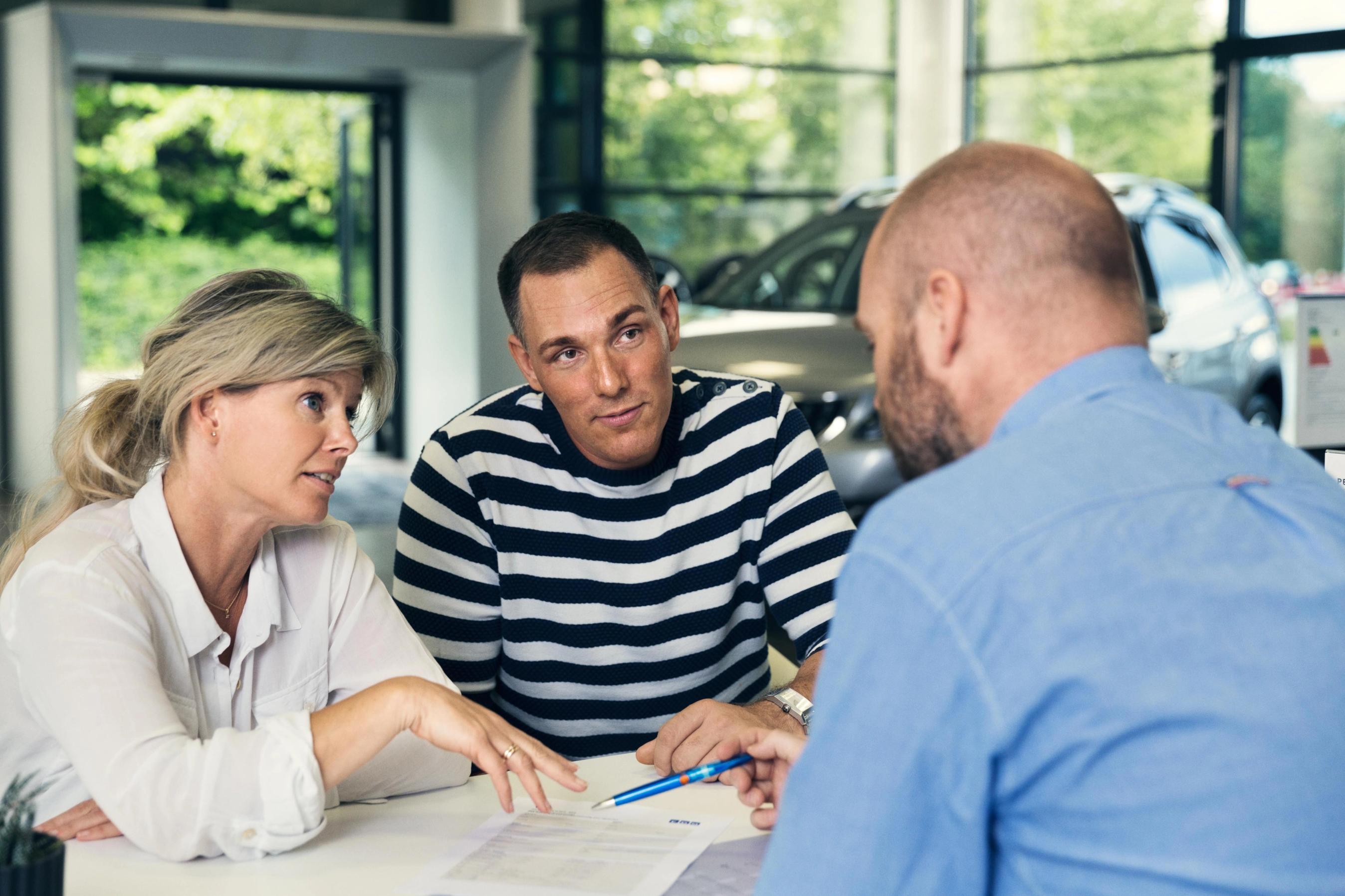 Par diskuterer af skriftlig aftale med en forhandler.