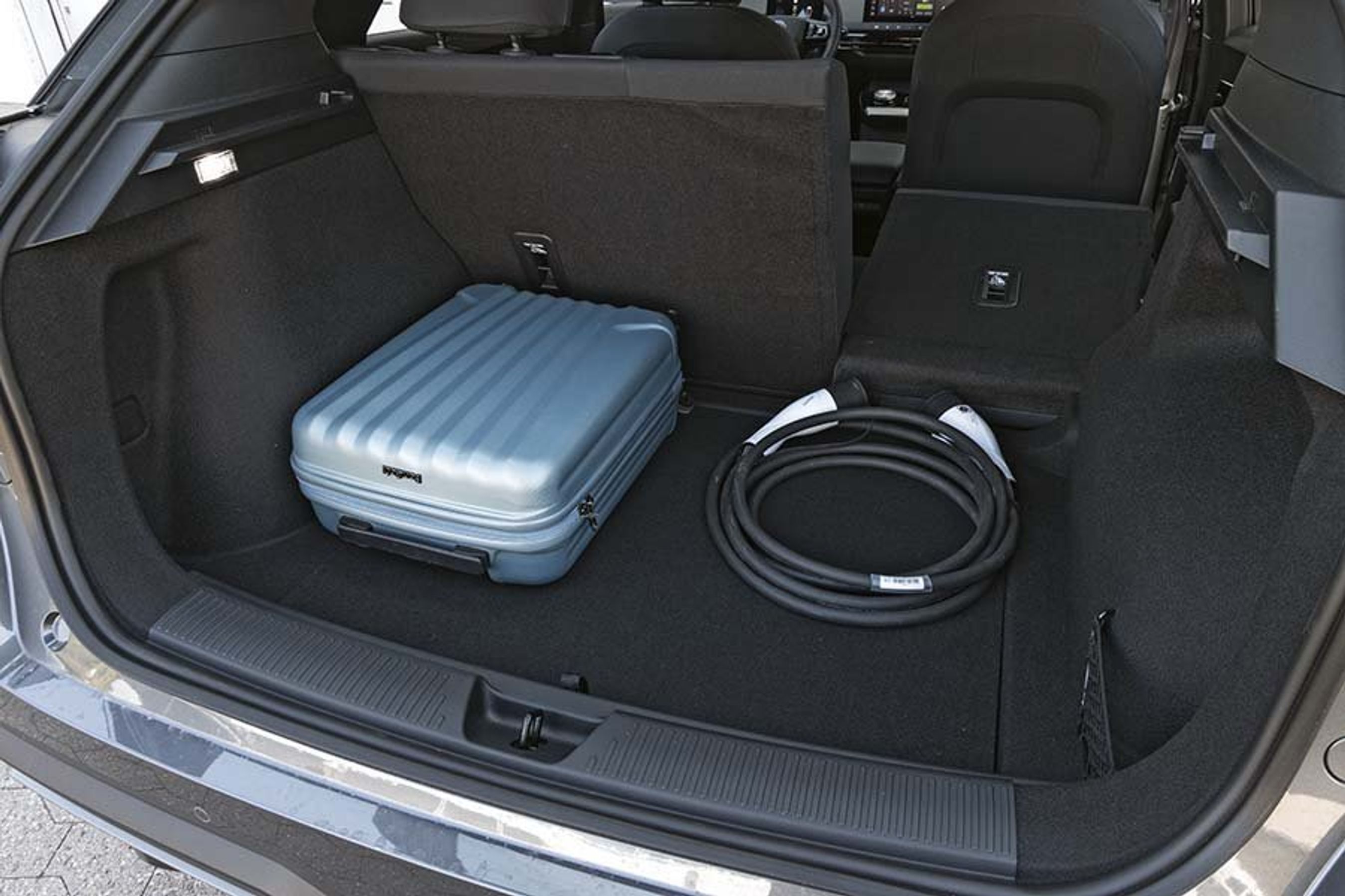 bagagerum i en MG 4 med en blå kuffert i