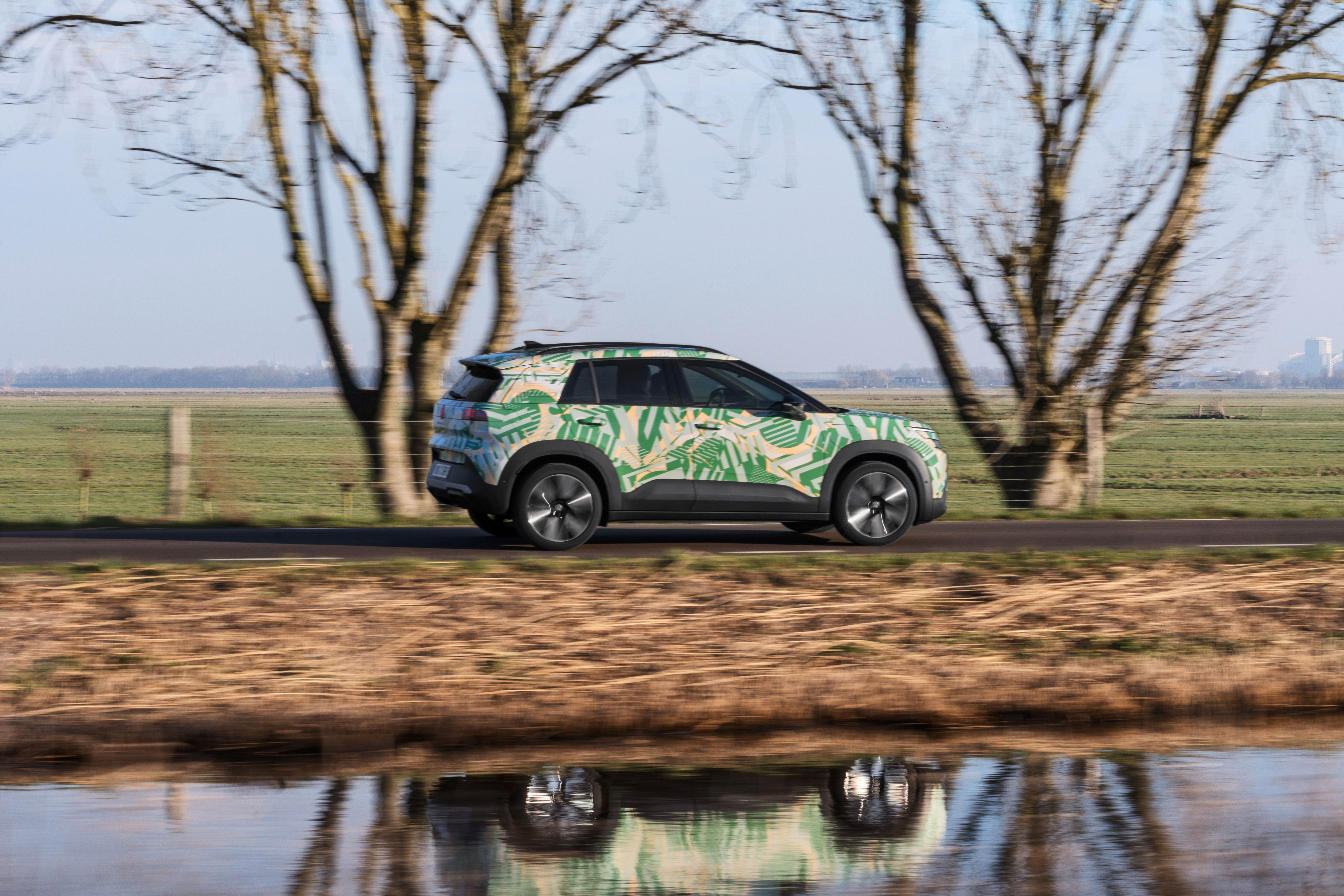 VW ID. Cross set fra siden, mens den kører langs vandløb på landet