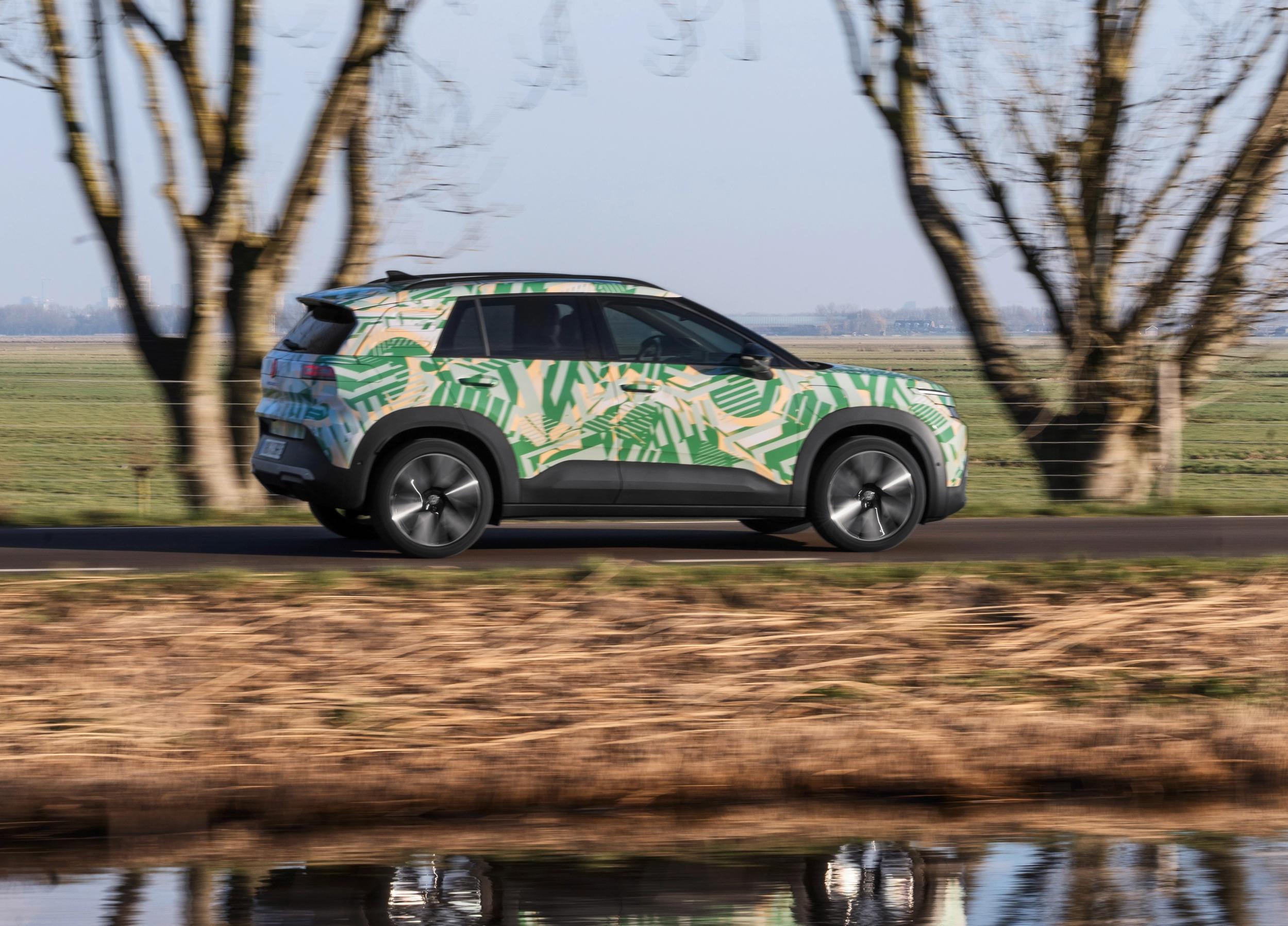 VW ID. Cross set fra siden, mens den kører langs vandløb på landet