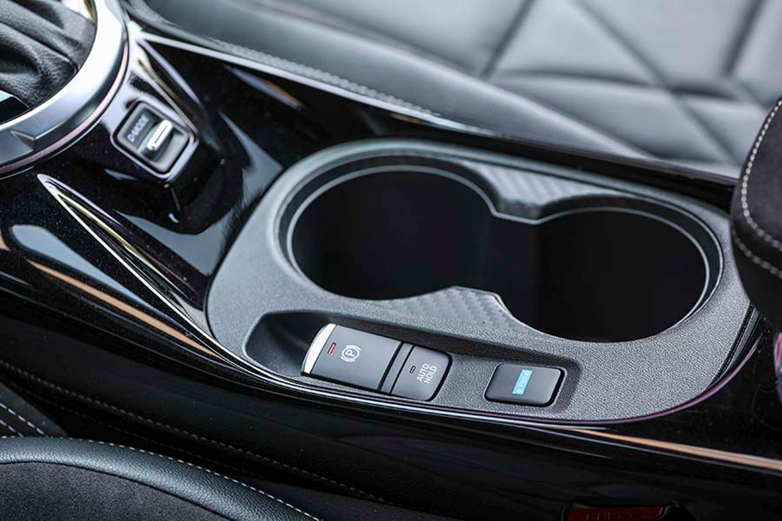 Mellem forsæderne er der en knap til e-Pedal, som er en funktion, der øger nedbremsningen fra elmotoren, når man slipper speederen. Derved kan man køre det meste af tiden med foden blot på speederen. Bilen standser dog ikke helt op af sig selv.