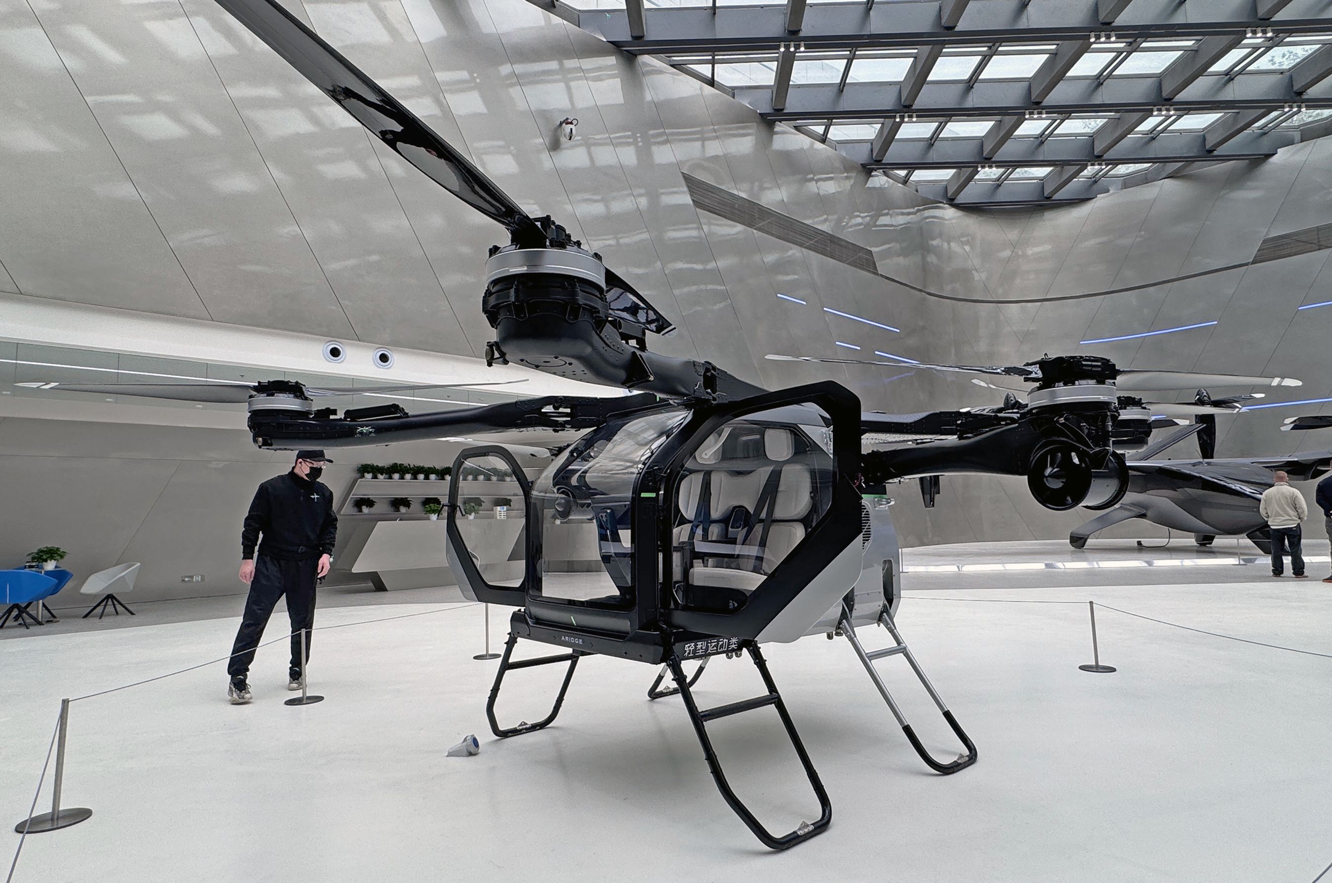 Persondrone inde i stor hal.