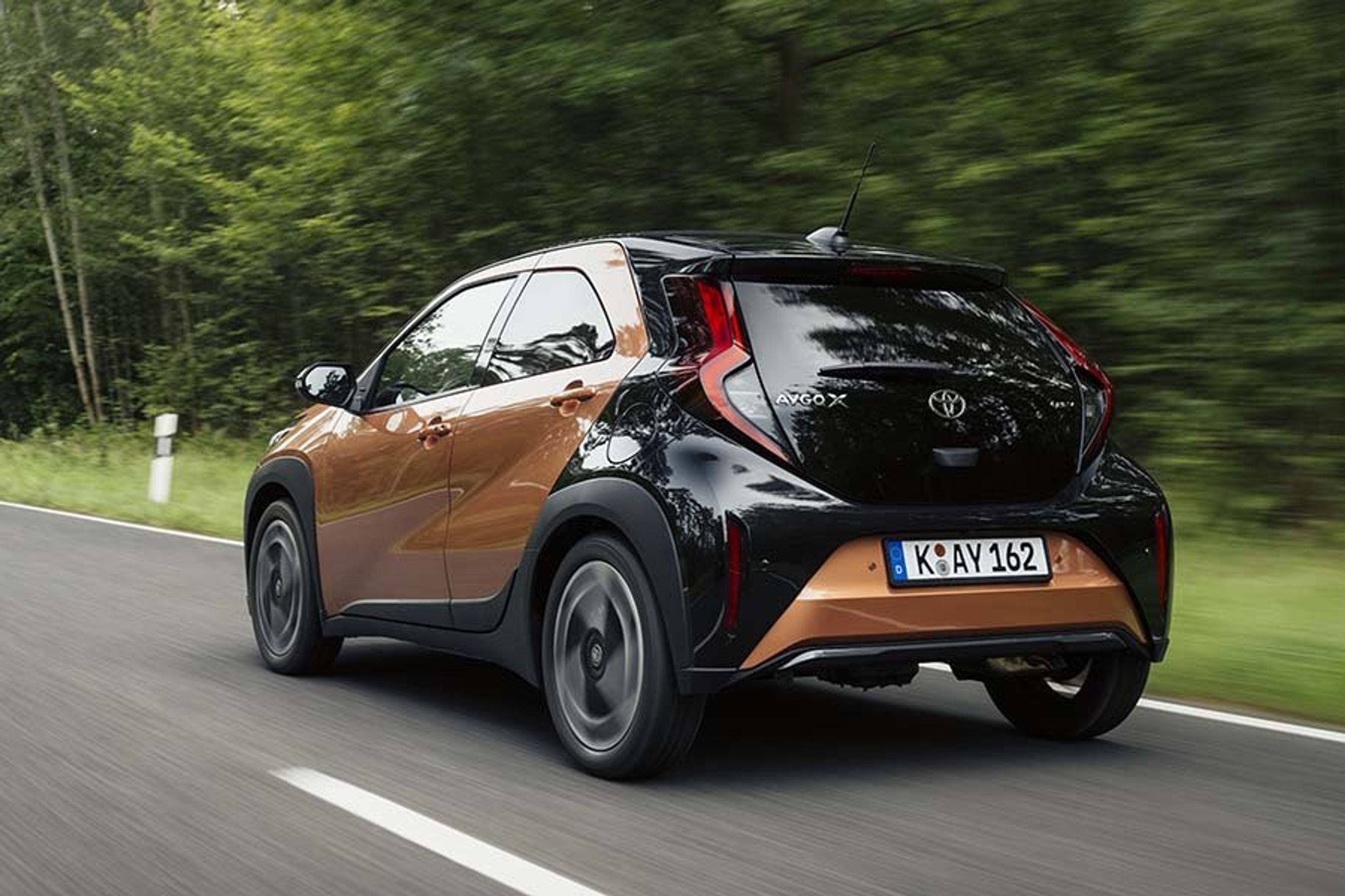 Toyota Aygo X set bagfra, mens den kører på skovvej