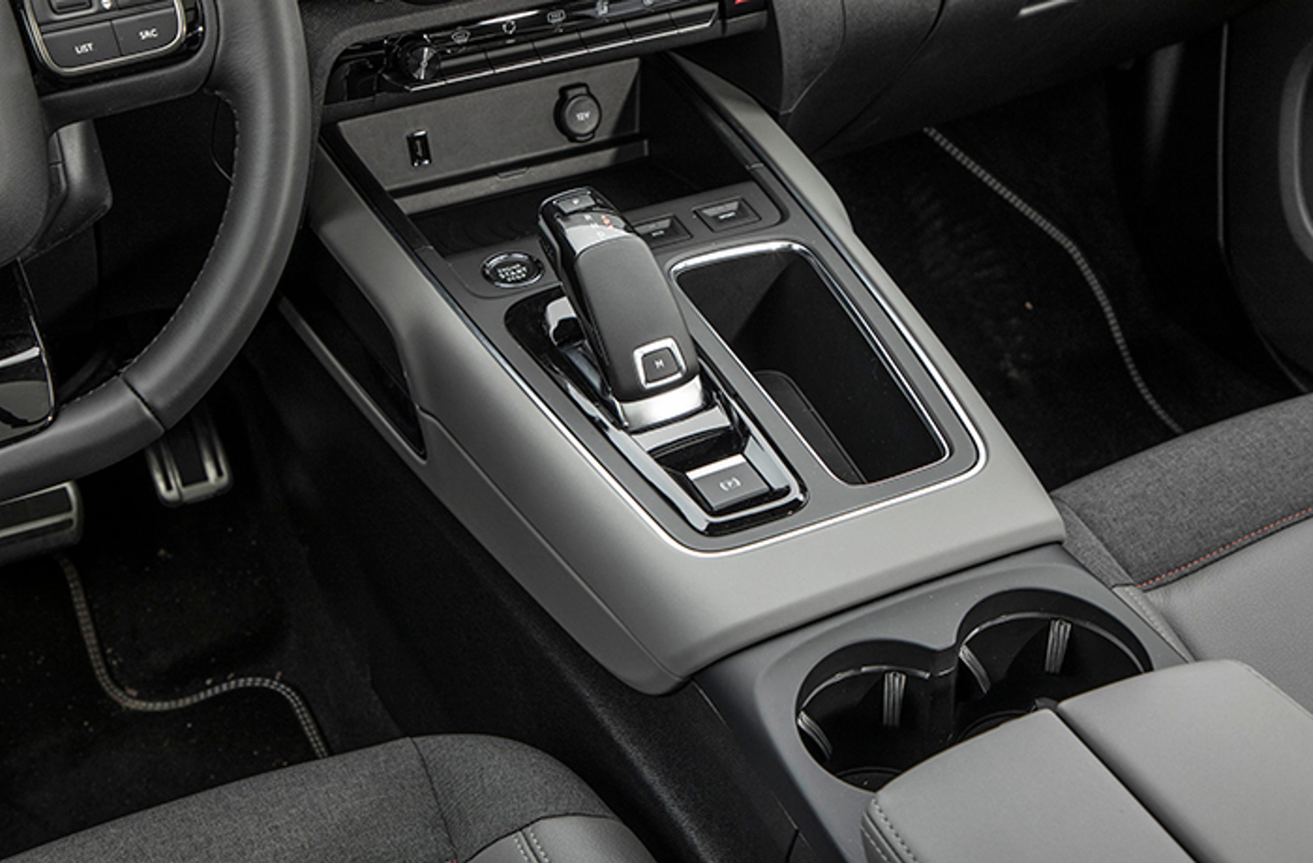 Gearvælgeren styrer automatgearets otte trin. Den er af den automatiske type, der selv går i ’P’, når motoren standses. Bemærk P-bremsen, der er elektrisk betjent.