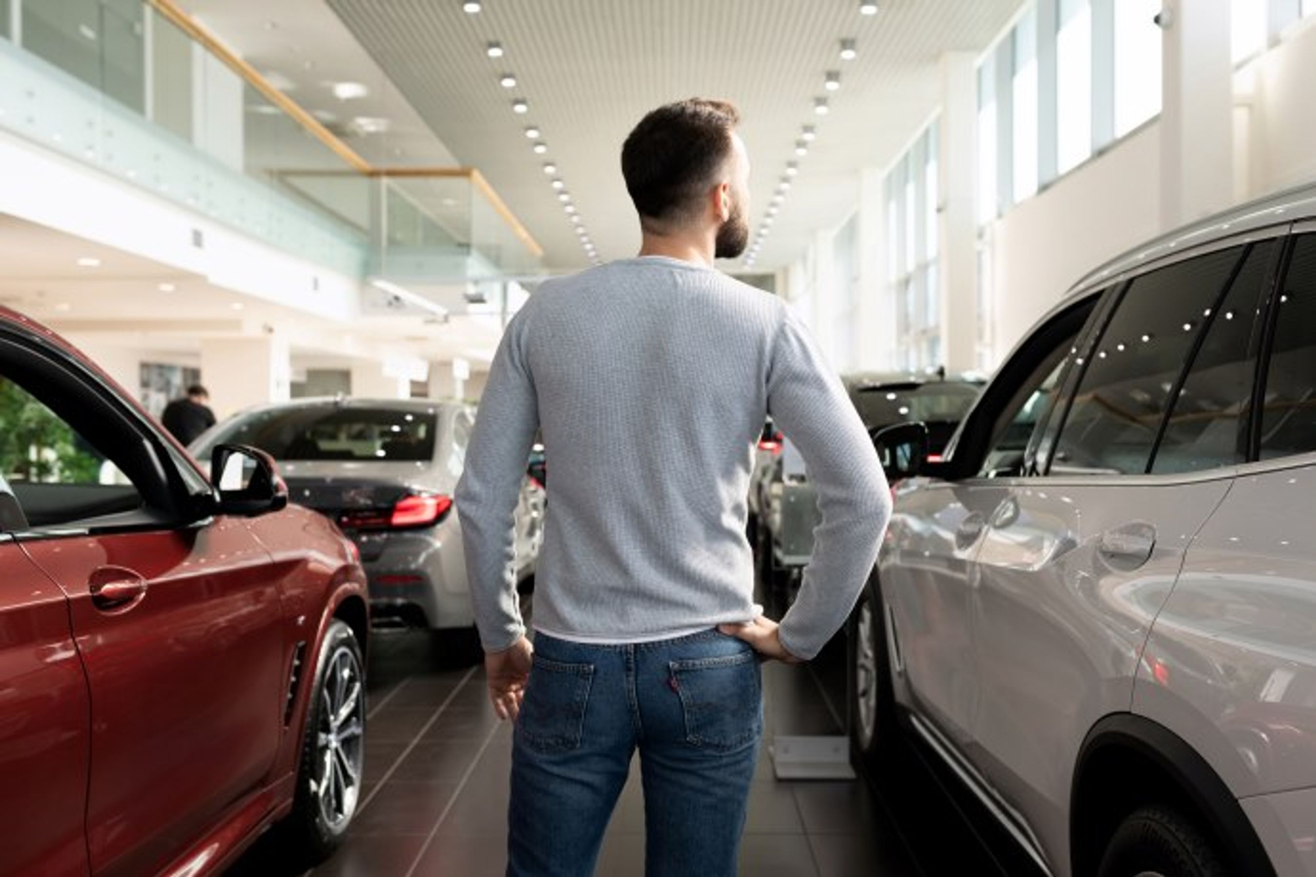 mand står hos en bilforhandler