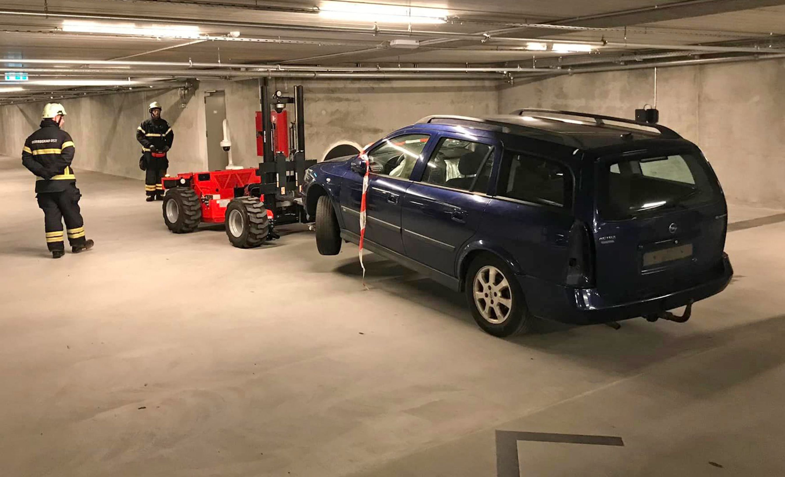 Brandfolk omkring bil.