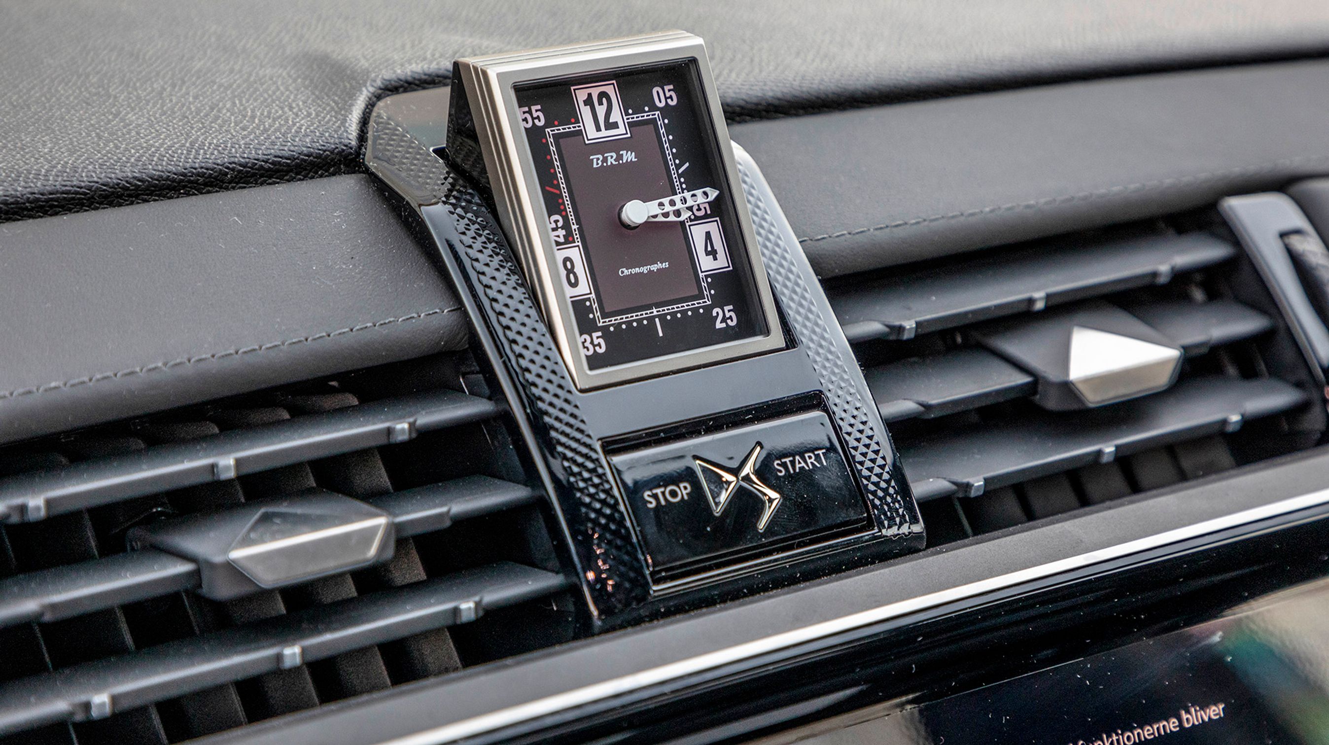 Designer-uret vipper op, når bilen startes. Under uret sidder kontakten til at starte og stoppe motoren med. Desværre skal den holdes uforholdsmæssigt lang tid inde, og det er generende i hverdagen.