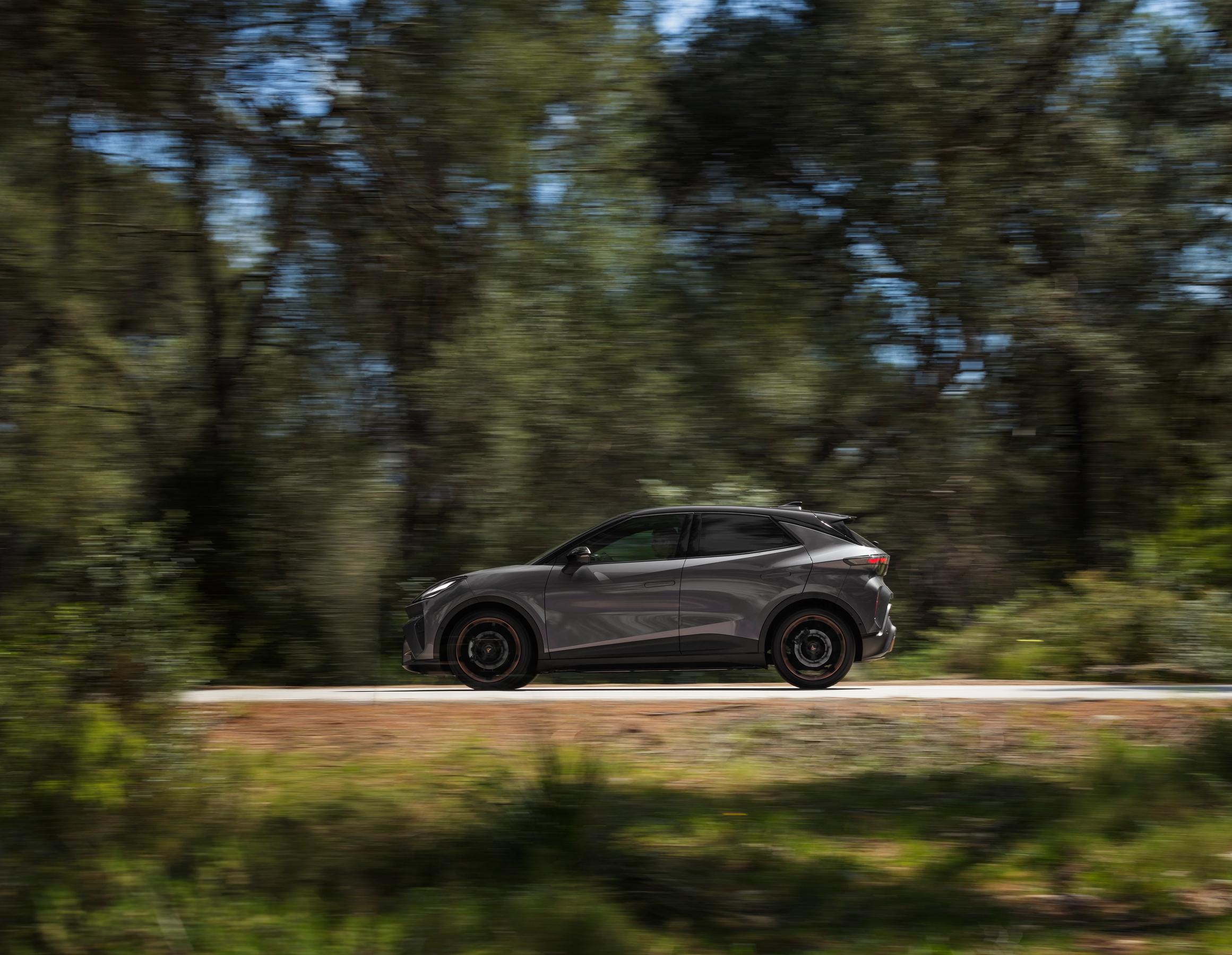 Cupra Raval VZ Extreme 2026 set fra siden kørende på en landevej med skov i baggrunden.