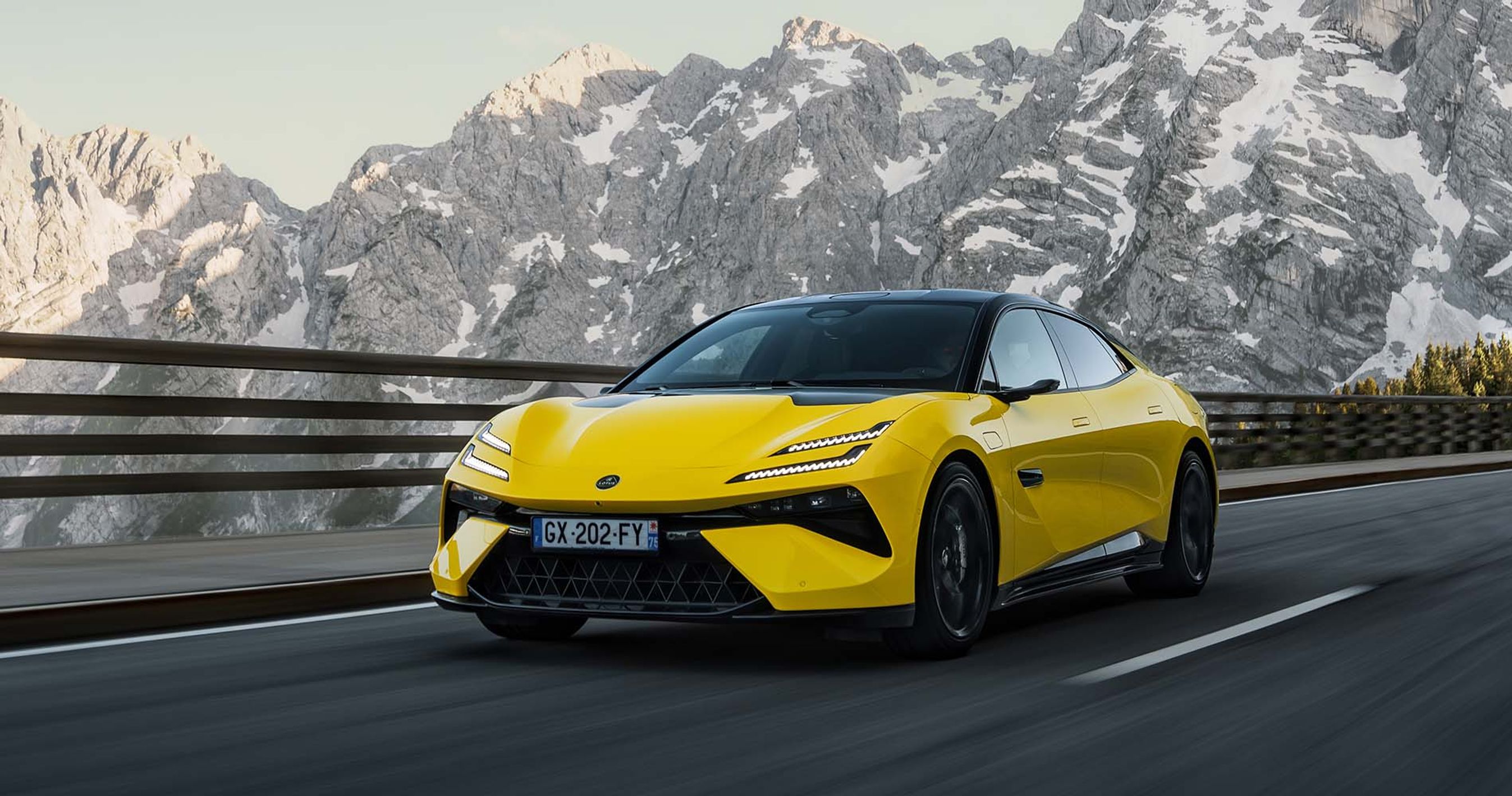 Gul Lotus Emeya kører på vej med bjerg i baggrunden